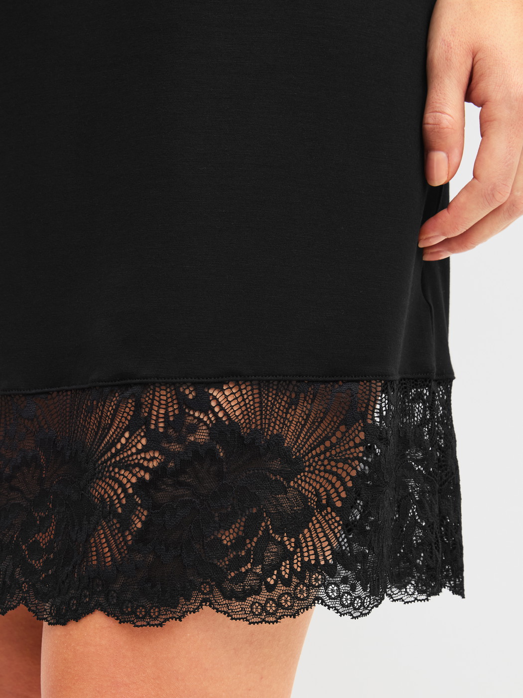 Damen-Model trägt Kurzarm-Nachthemd, Länge 95 cm aus Modal in Schwarz, Spitze aus Serie Elegant Dreams von CALIDA, Detail