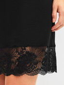 Damen-Model trägt Kurzarm-Nachthemd, Länge 95 cm aus Modal in Schwarz, Spitze aus Serie Elegant Dreams von CALIDA, Detail