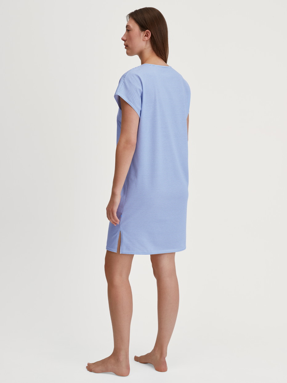 Women model is wearing Short-Sleeve Nightdress – 95 cm Length made of 100% Cotton in Blue, Patterned from the Lovely Nights series by CALIDA, Back view
