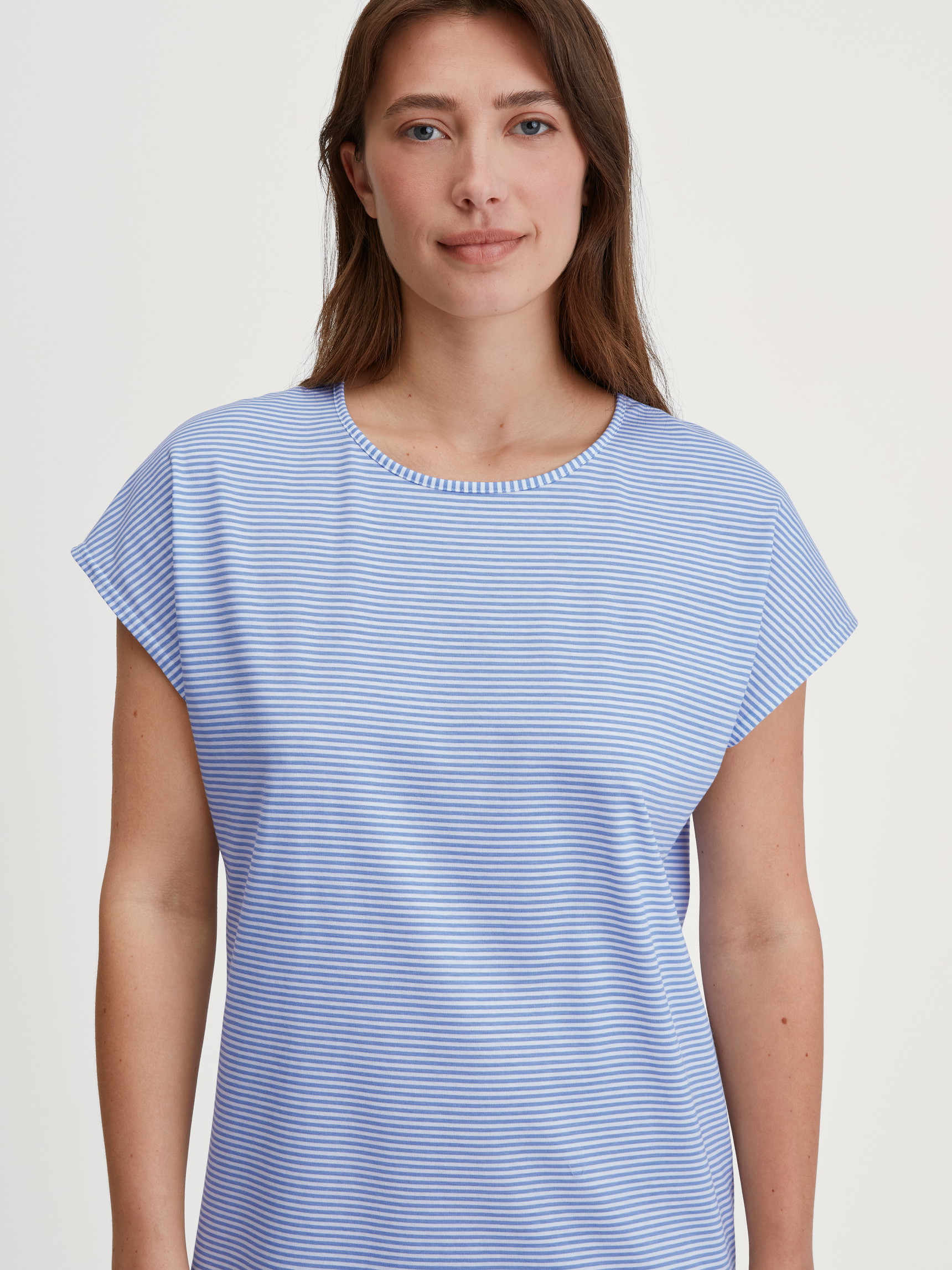 Women model is wearing Short-Sleeve Nightdress – 95 cm Length made of 100% Cotton in Blue, Patterned from the Lovely Nights series by CALIDA, Detail