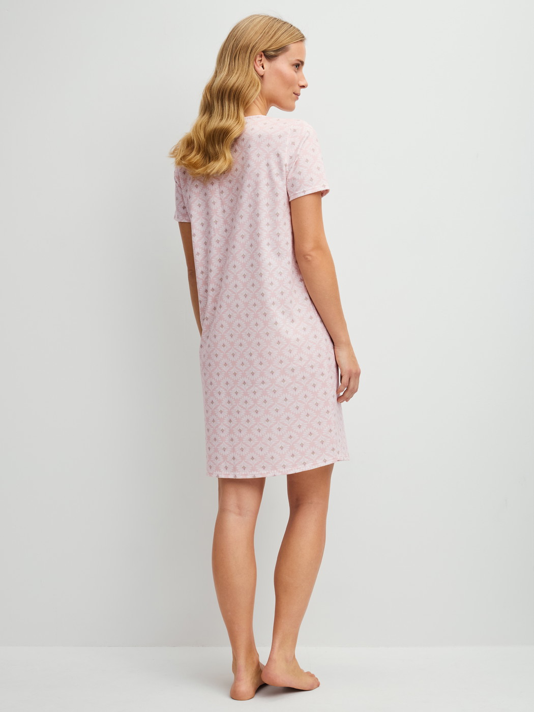 Women model is wearing Short-sleeved nightdress, length 95 cm made of 100% Cotton in Pink, Floral from the Cotton Special series by CALIDA, Back view