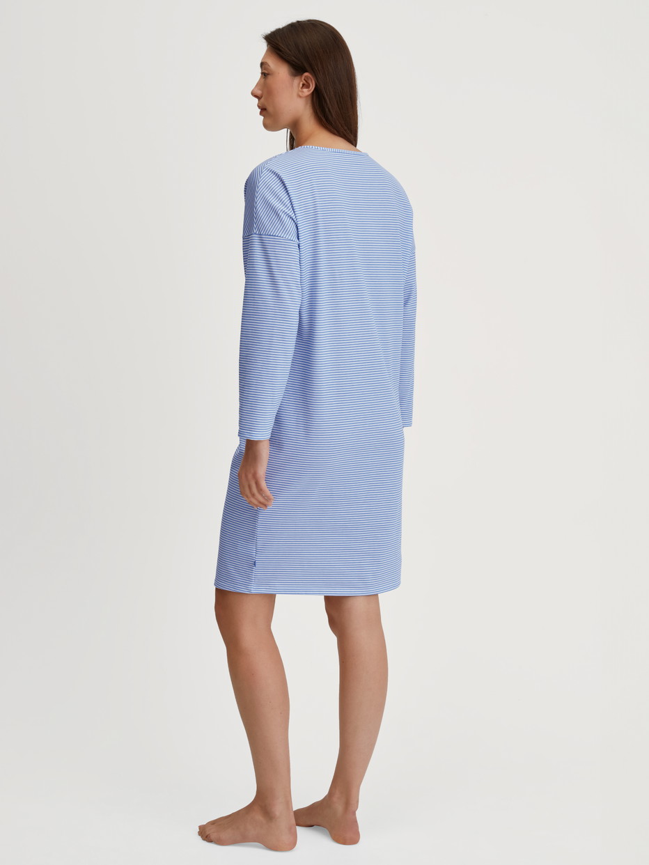 Women model is wearing Long Sleeve Nightdress –100 cm Length made of 100% Cotton in Blue, Patterned from the Lovely Nights series by CALIDA, Back view