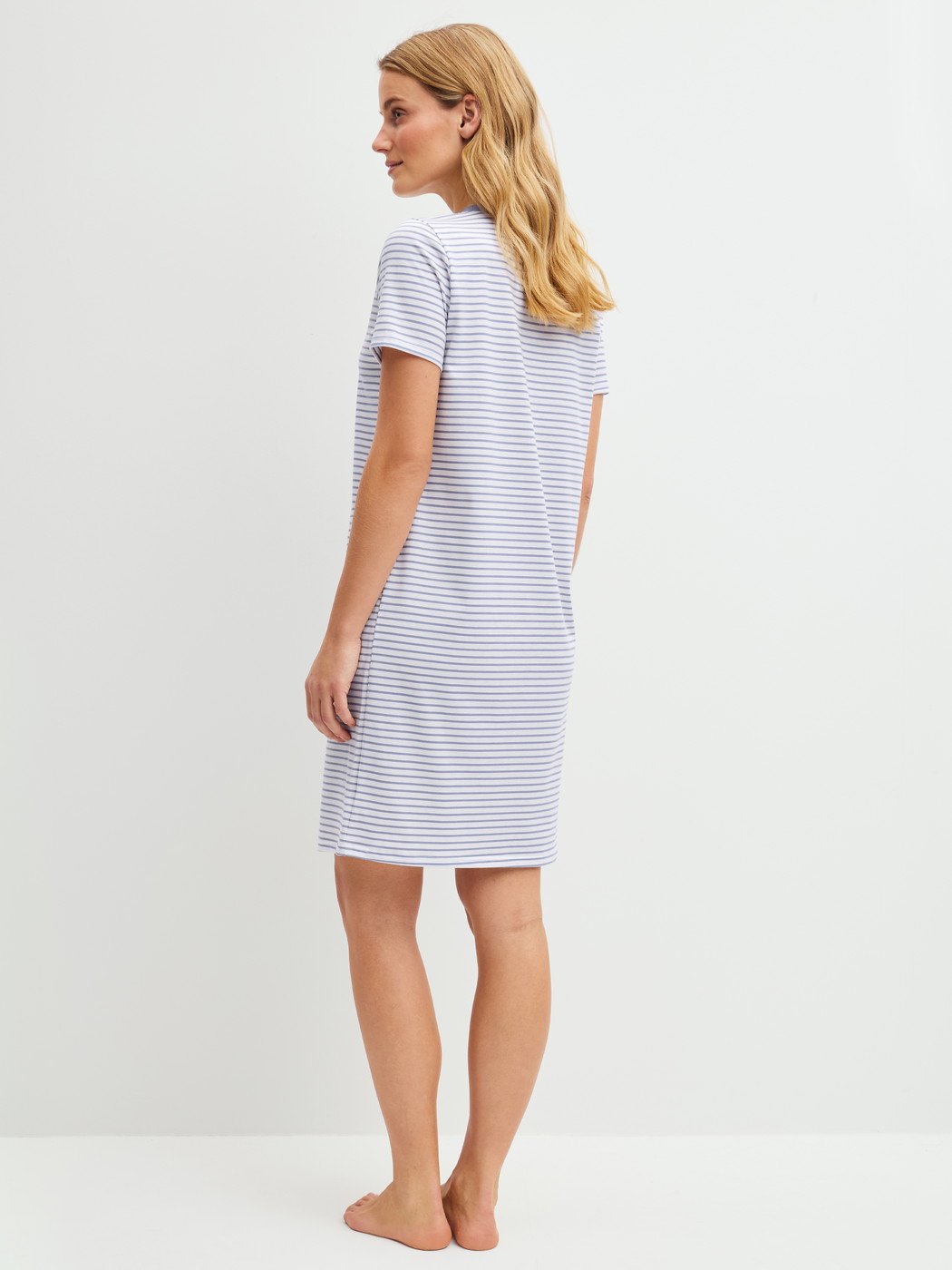 Women model is wearing Short-sleeved nightdress, length 95 cm made of 100% Cotton in Blue, Striped from the Cotton Special series by CALIDA, Back view