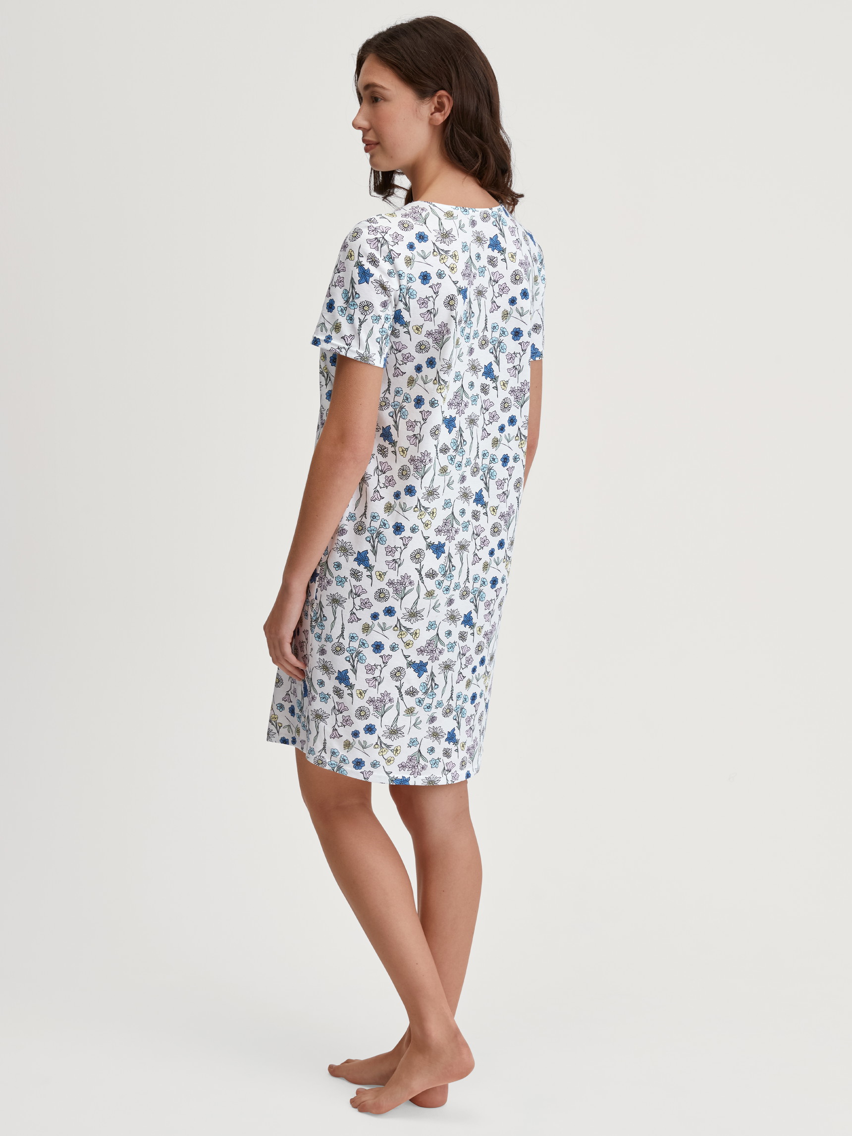Damen-Model trägt Kurzarm-Nachthemd, Länge 95 cm aus 100% Baumwolle in Blau, Floral aus Serie Flower Nights von CALIDA, Rückansicht