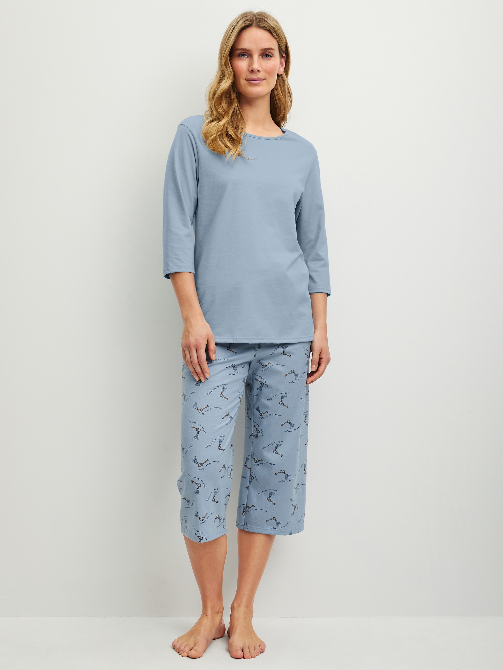Damen-Model trägt Capri-Pyjama aus 100% Baumwolle in Blau, Gemustert aus Serie Hotel Nights von CALIDA, Vorderansicht