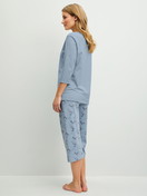 Damen-Model trägt Capri-Pyjama aus 100% Baumwolle in Blau, Gemustert aus Serie Hotel Nights von CALIDA, Rückansicht