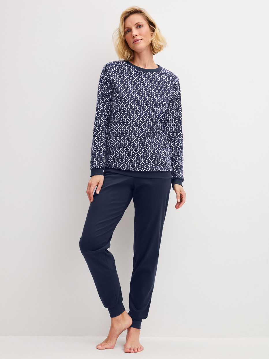 Damen-Model trägt Bündchen-Pyjama aus 100% Baumwolle in Blau, Gemustert aus Serie Midnight Hearts von CALIDA, Vorderansicht