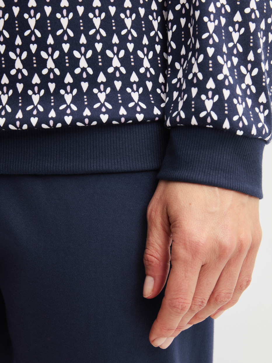 Damen-Model trägt Bündchen-Pyjama aus 100% Baumwolle in Blau, Gemustert aus Serie Midnight Hearts von CALIDA, Detail