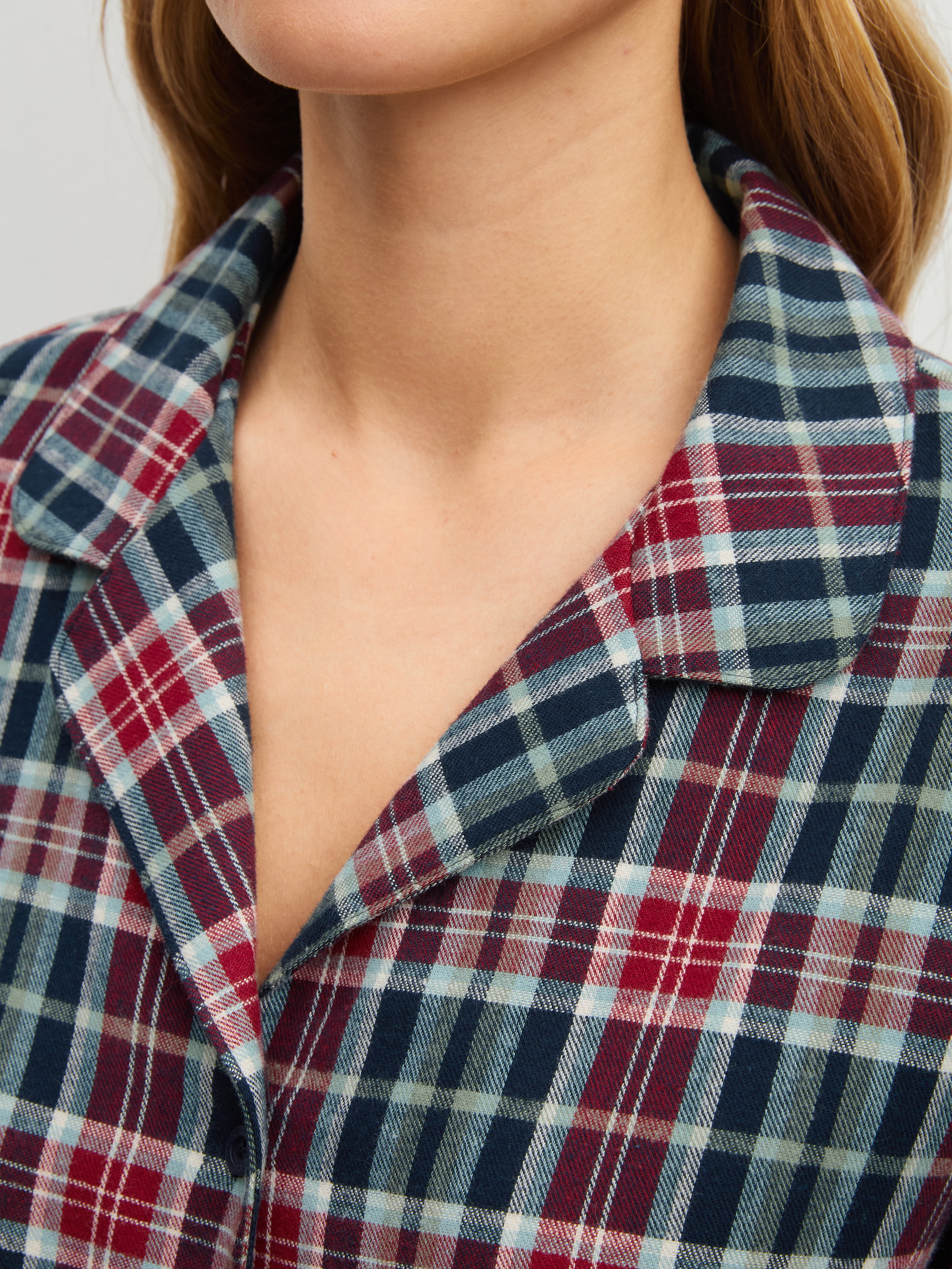 Damen-Model trägt Flanell-Pyjama mit Knöpfen aus 100% Baumwolle in Blau, Kariert aus Serie Holiday Dreams von CALIDA, Detail