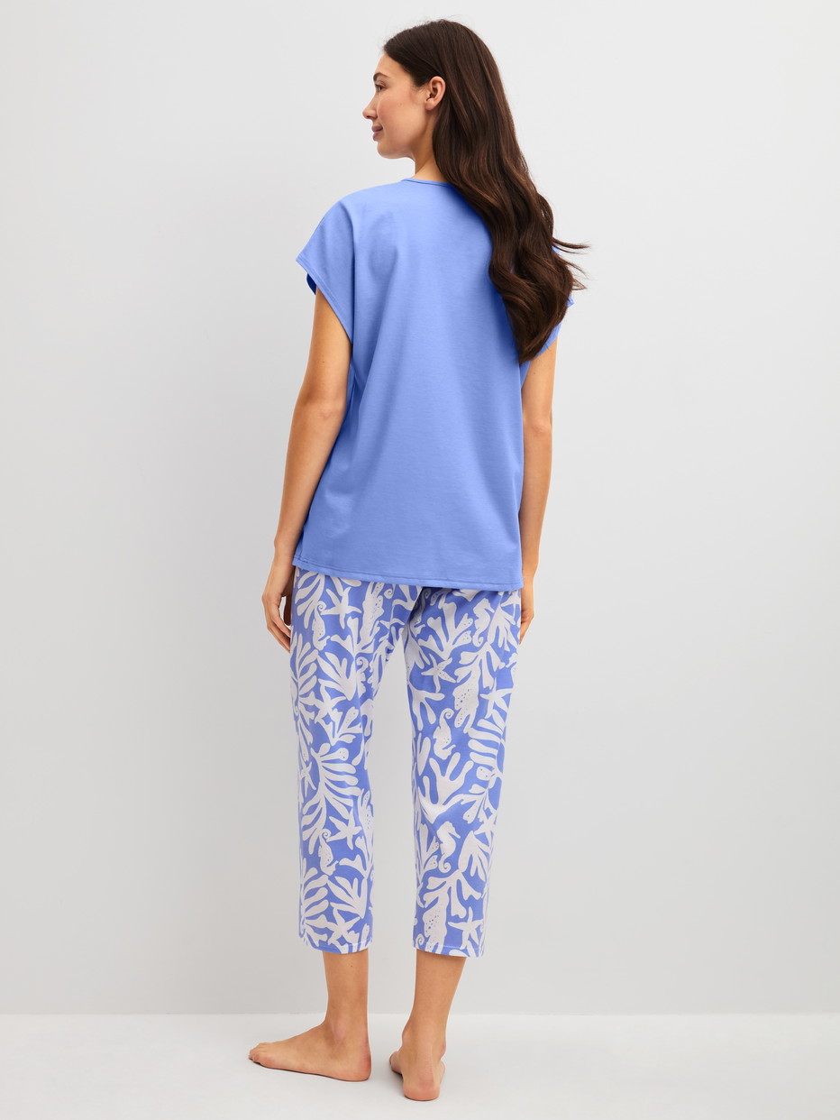 Damen-Model trägt 7/8-Pyjama aus 100% Baumwolle in Blau, Floral aus Serie Cotton Special von CALIDA, Rückansicht