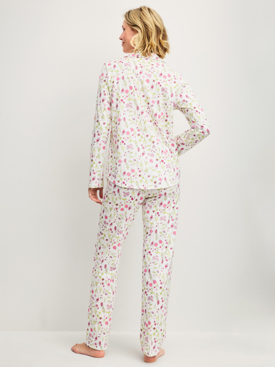 Women model is wearing Button-Up Pyjama made of 100% Cotton in Pink, Floral from the Cotton Special series by CALIDA, Back view