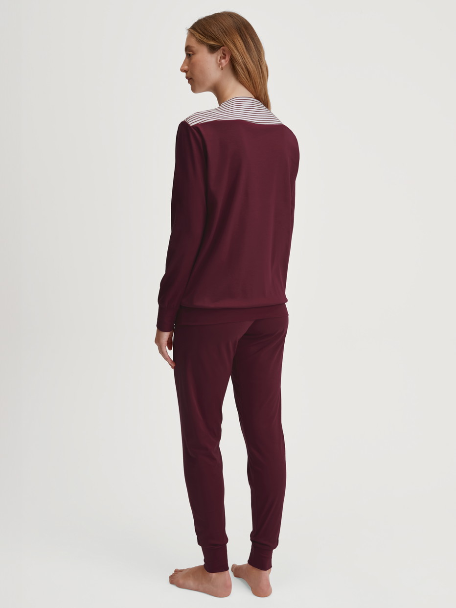 Women model is wearing Pyjama with cuff made of 100% Cotton in Red, Patterned from the Season Special series by CALIDA, Back view