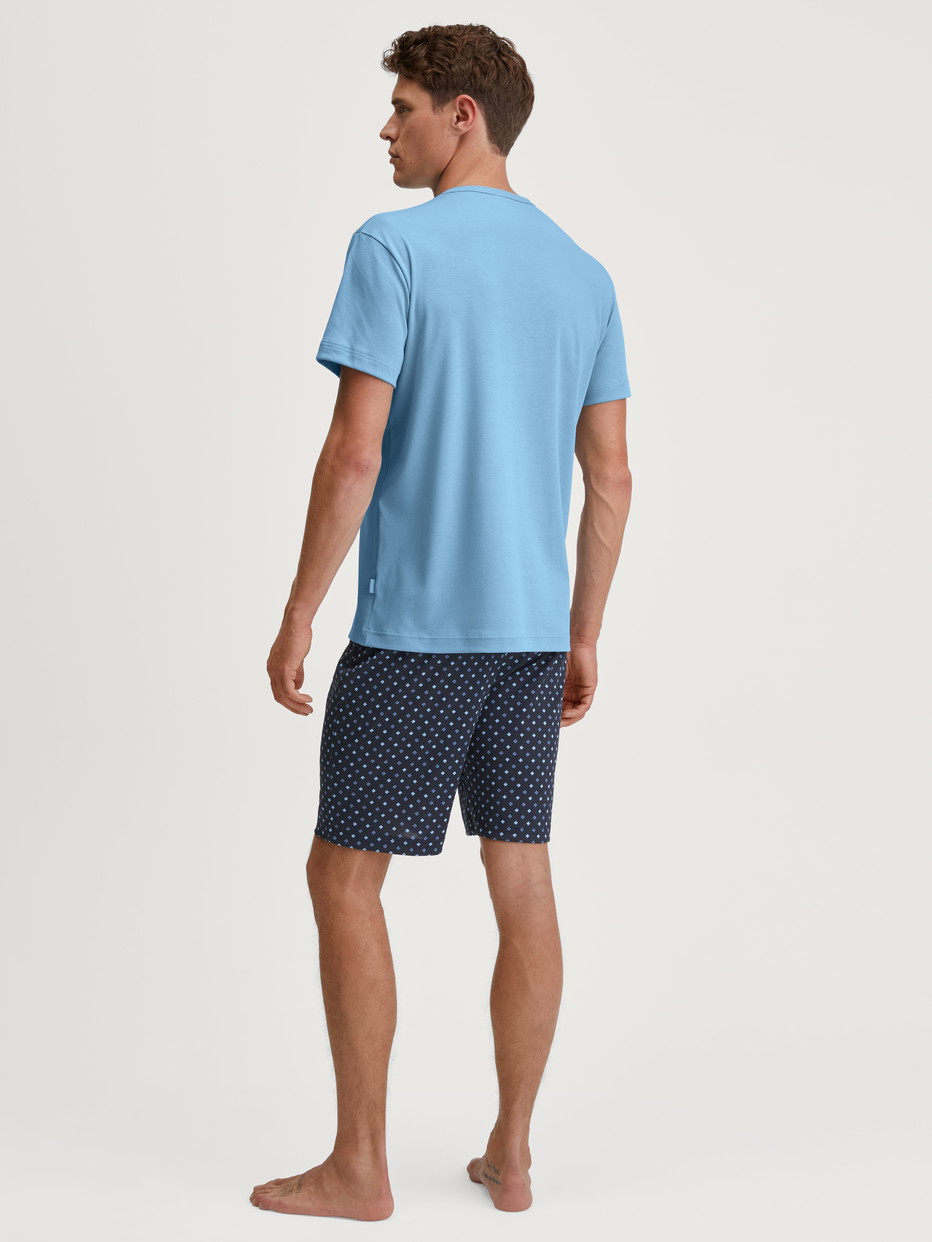 Herren-Model trägt Kurz-Pyjama aus 100% Baumwolle in Blau, Gemustert aus Serie Relax Streamline von CALIDA, Rückansicht
