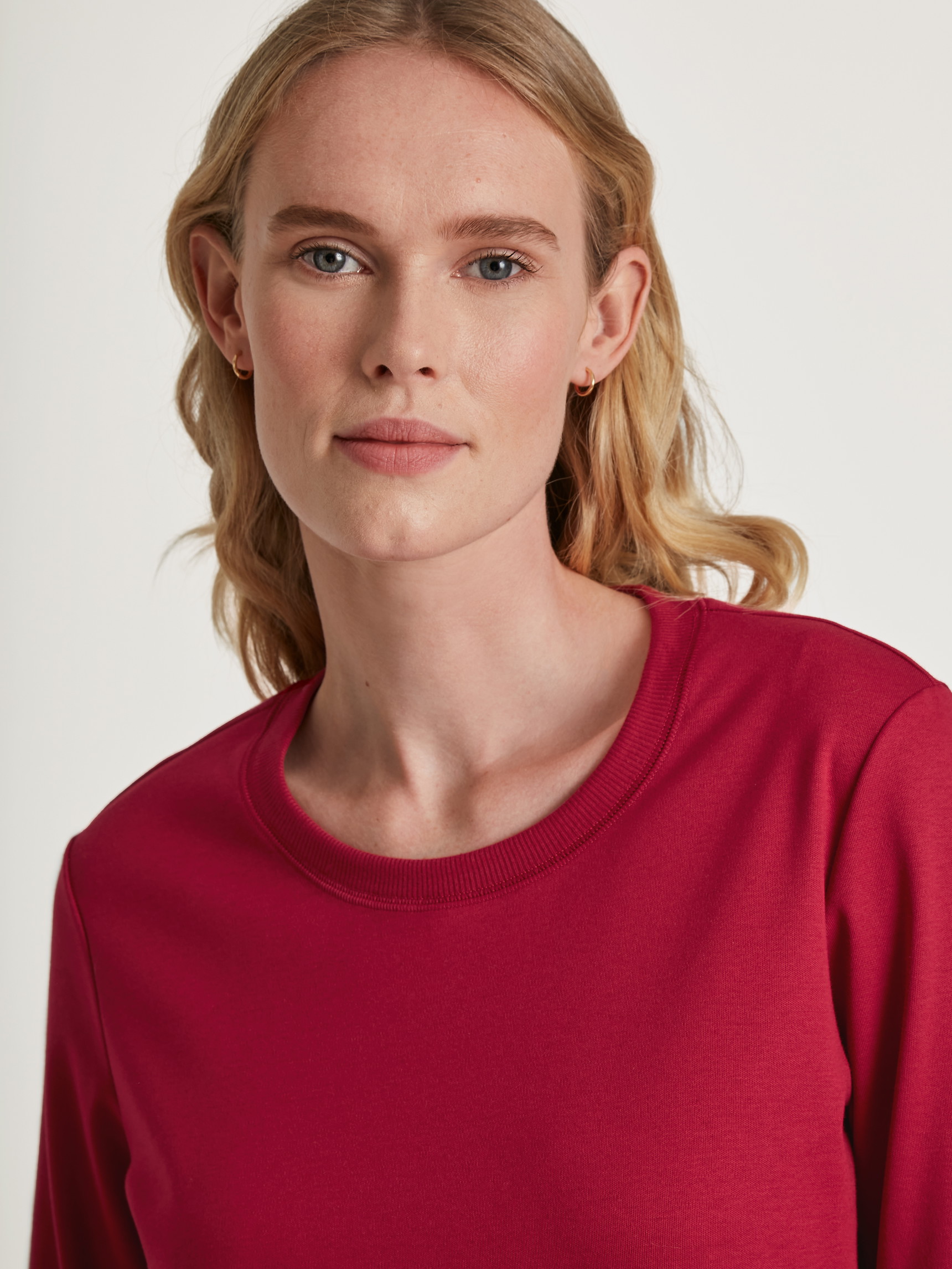 Women model is wearing Pyjamas, long made of 100% Cotton in Red, Motif from the Family & Friends series by CALIDA