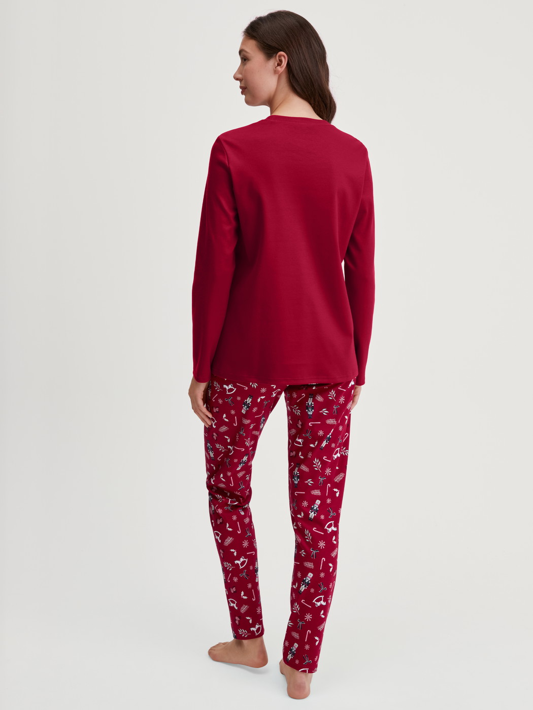 Damen-Model trägt Pyjama, lang aus 100% Baumwolle in Rot, Gemustert aus Serie Family & Friends von CALIDA, Rückansicht