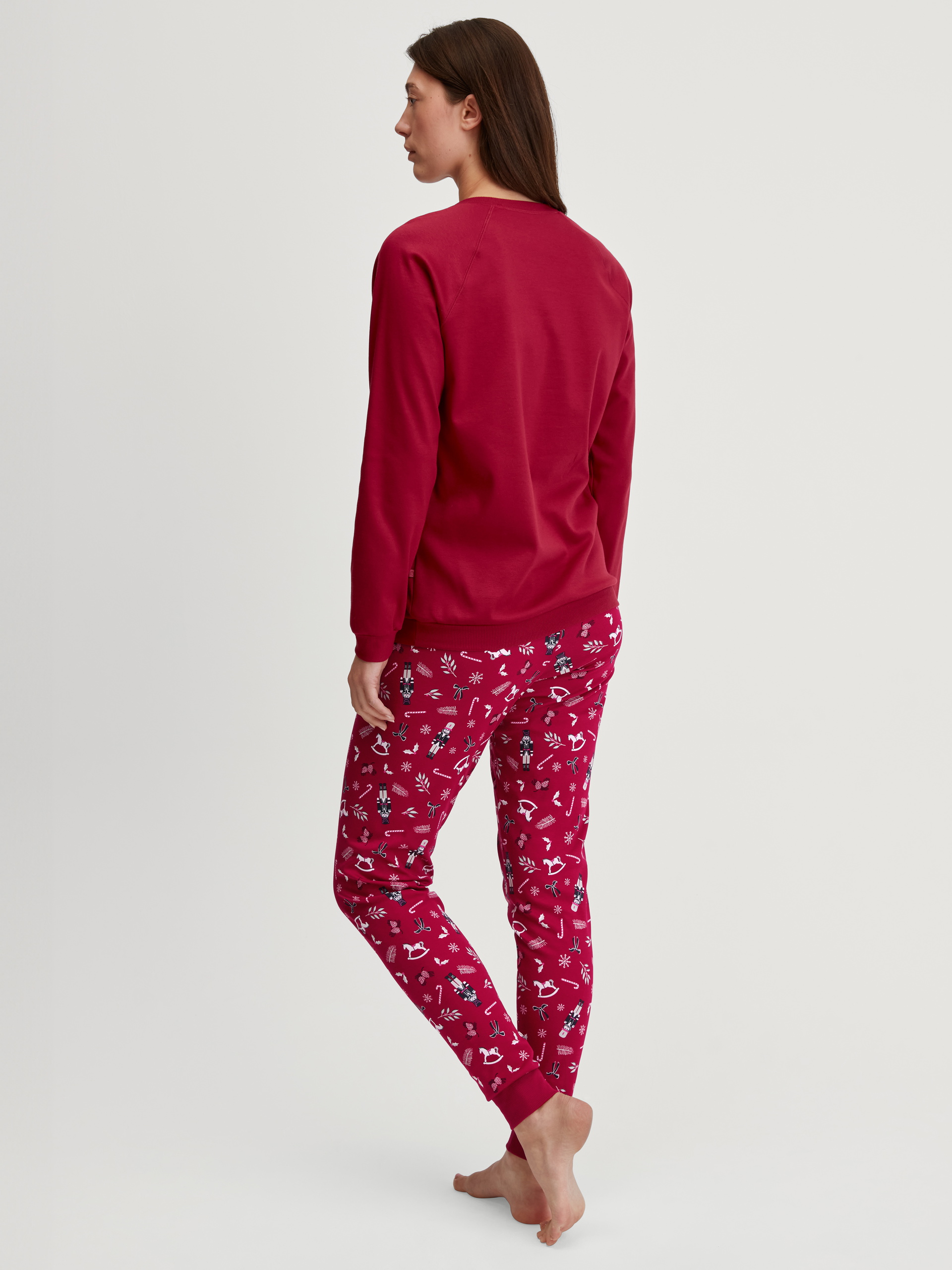 Women model is wearing Pyjama with cuff made of 100% Cotton in Red, Patterned from the Family & Friends series by CALIDA, Back view