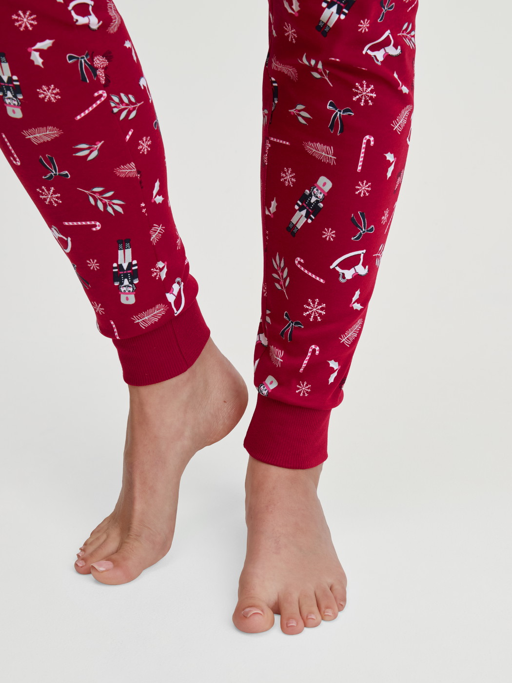 Women model is wearing Pyjama with cuff made of 100% Cotton in Red, Patterned from the Family & Friends series by CALIDA, Detail