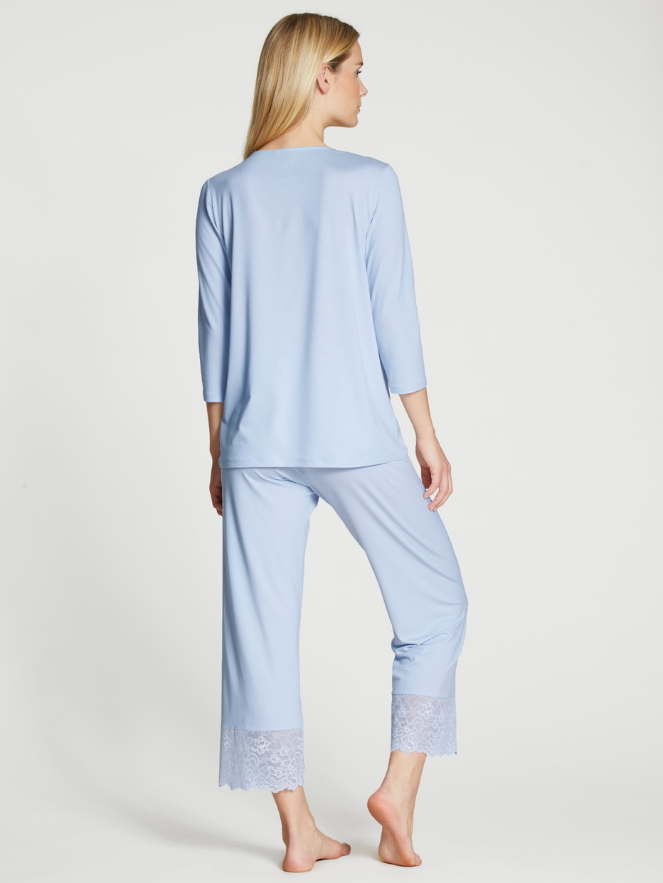 Women model is wearing 7/8 pyjama made of Modal in Blue, Lace from the Elegant Dreams series by CALIDA, Back view