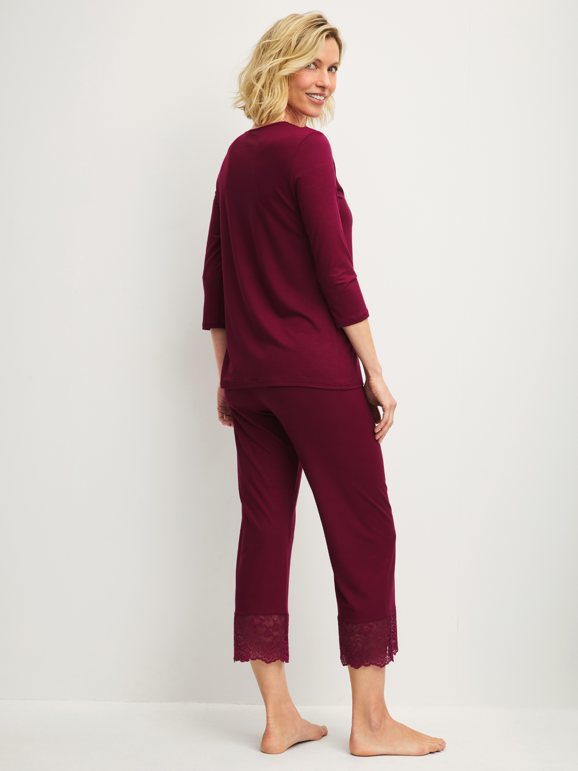 Women model is wearing 7/8 pyjama made of Modal in Red, Lace from the Season Special series by CALIDA, Back view