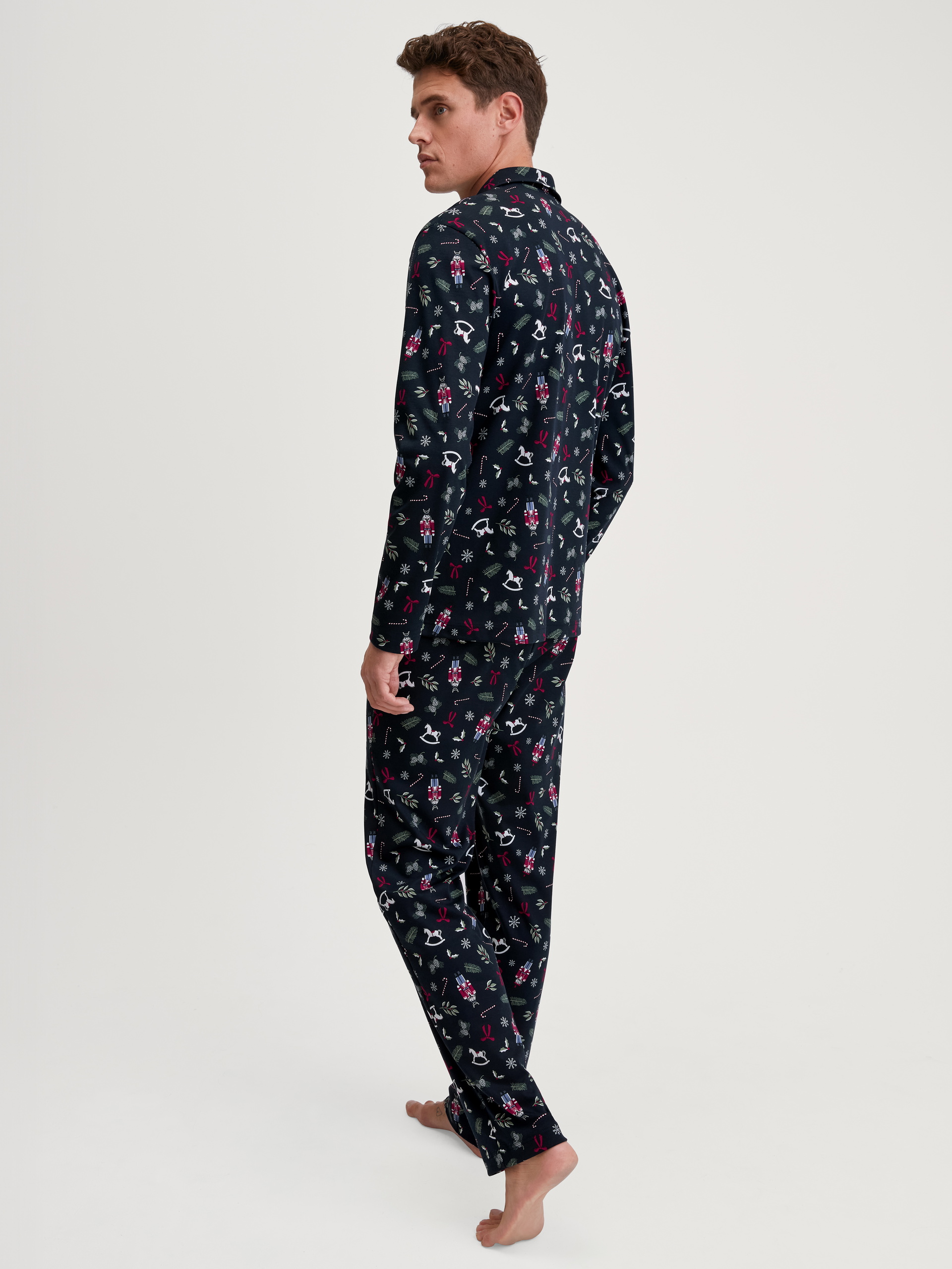 Herren-Model trägt Pyjama mit Knöpfen aus 100% Baumwolle in Blau, Gemustert aus Serie Family & Friends von CALIDA, Rückansicht