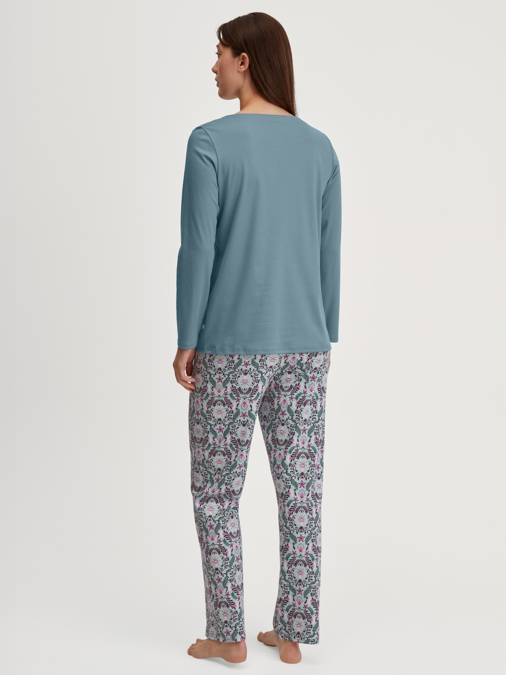 Women model is wearing Pyjamas, long made of 100% Cotton in Blue, Patterned from the Autumn Dreams series by CALIDA, Back view