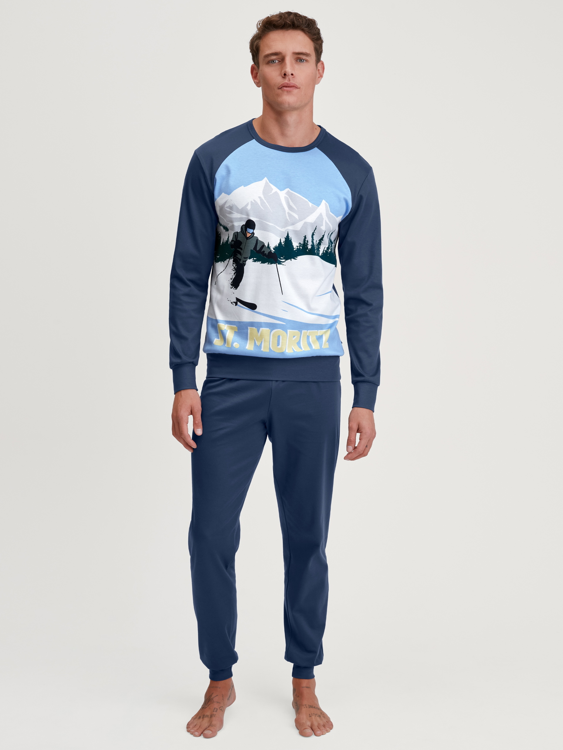 Herren-Model trägt Bündchen-Pyjama aus 100% Baumwolle in Blau, Motiv aus Serie Relax Ski Resort von CALIDA, Vorderansicht