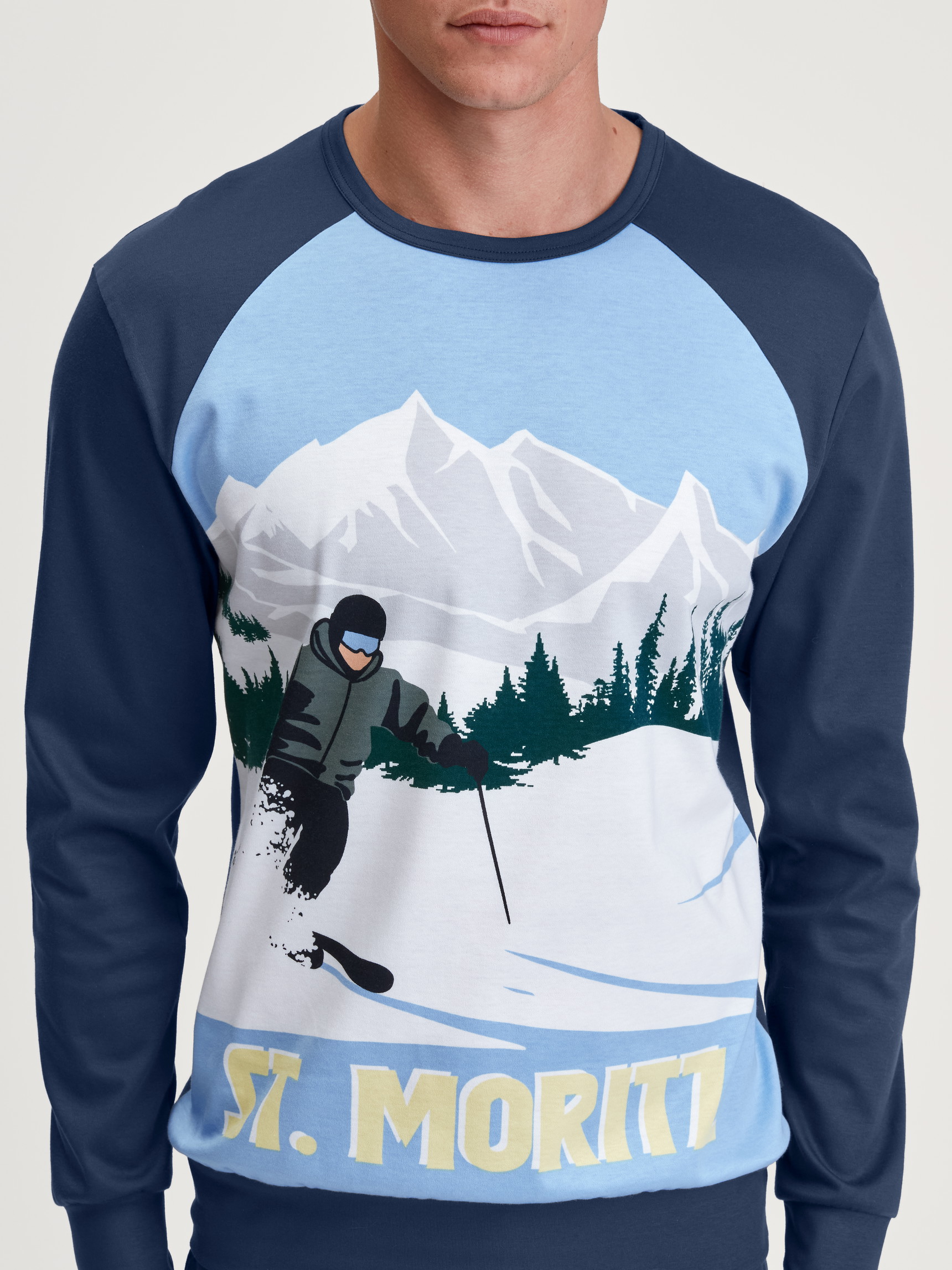 Herren-Model trägt Bündchen-Pyjama aus 100% Baumwolle in Blau, Motiv aus Serie Relax Ski Resort von CALIDA, Detail