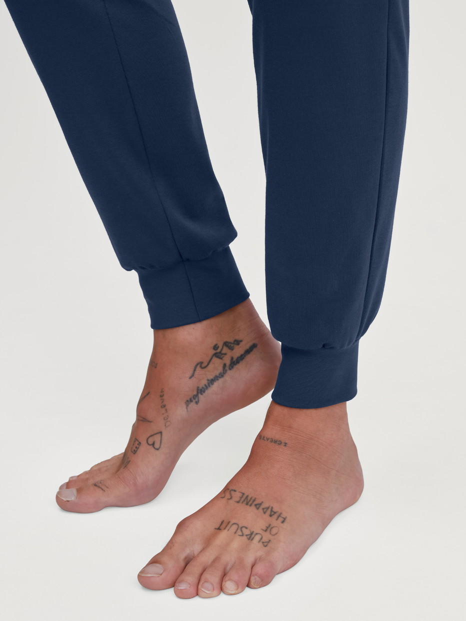 Herren-Model trägt Bündchen-Pyjama aus 100% Baumwolle in Blau, Motiv aus Serie Relax Ski Resort von CALIDA, Detail