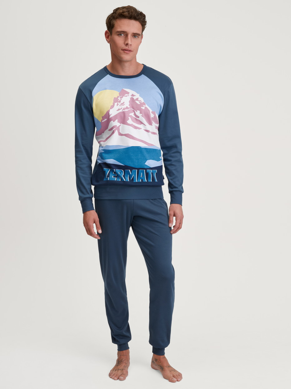 Men model is wearing Pyjama with cuff made of 100% Cotton in Blue, Motif from the Relax Ski Resort series by CALIDA, Front view