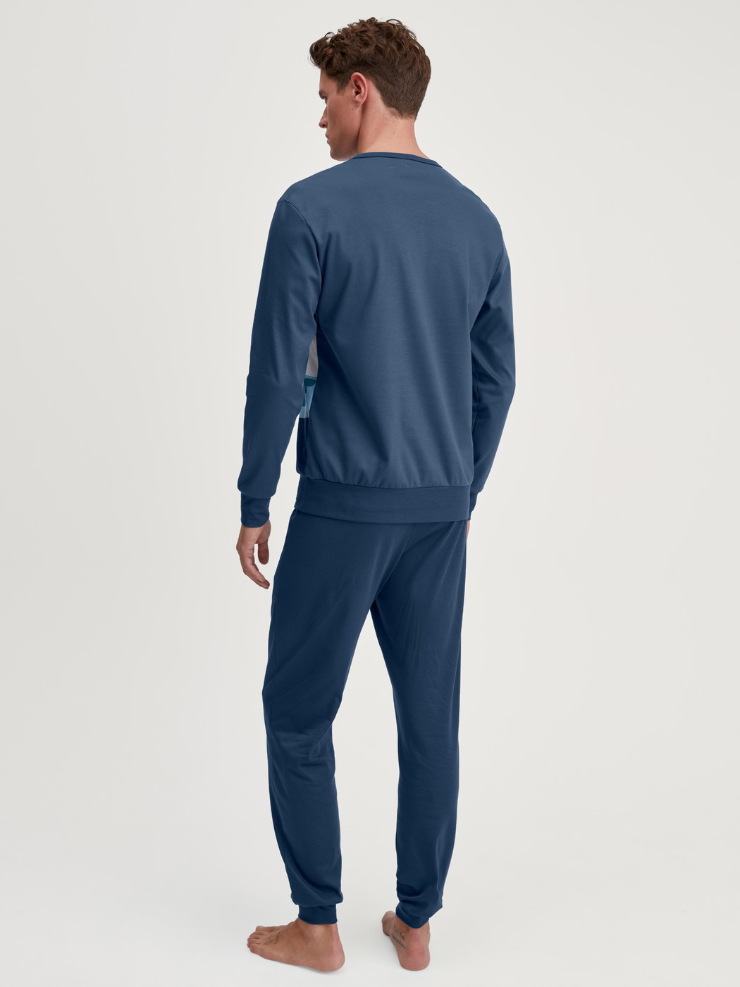 Men model is wearing Pyjama with cuff made of 100% Cotton in Blue, Motif from the Relax Ski Resort series by CALIDA, Back view