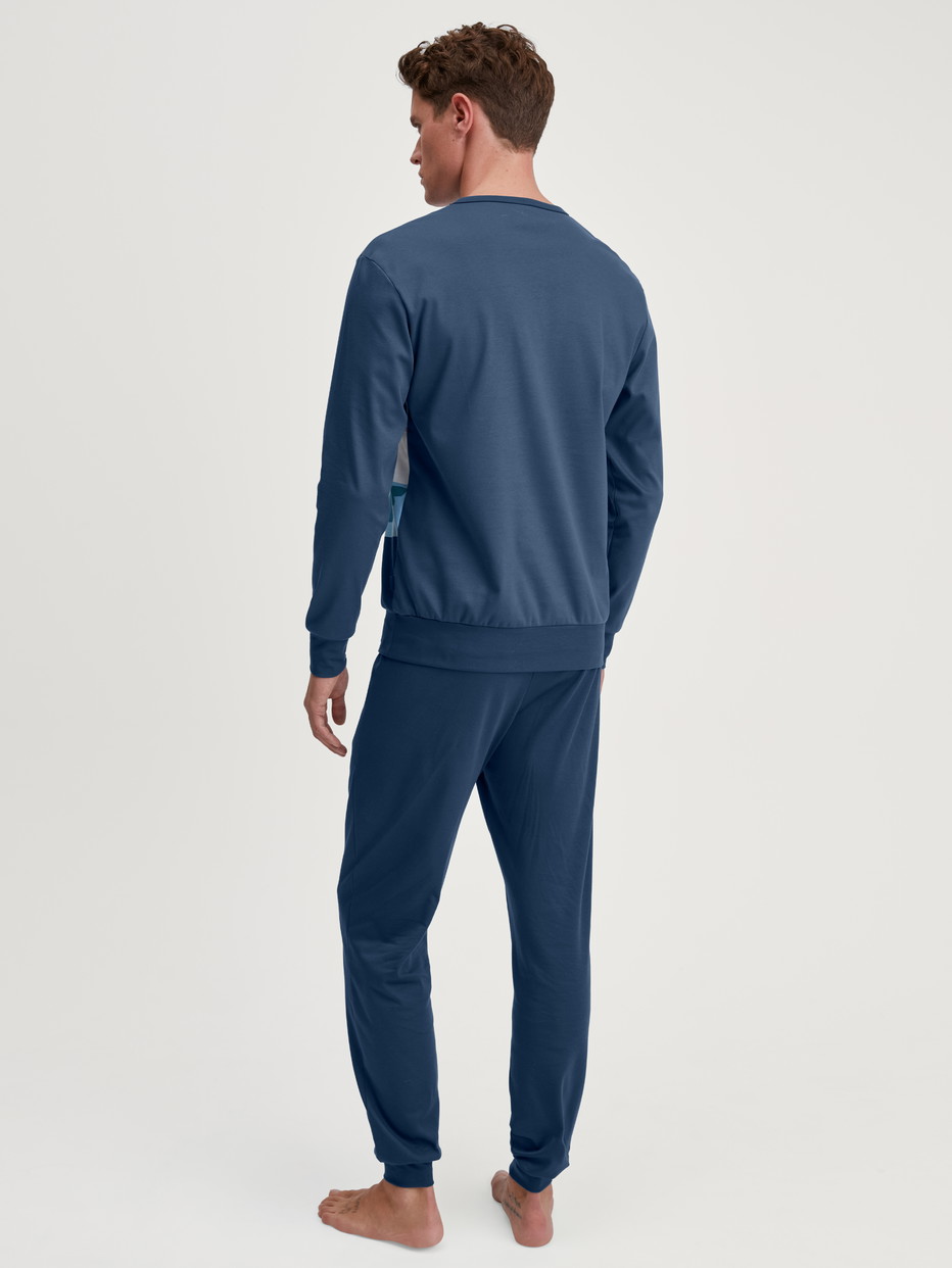 Men model is wearing Pyjama with cuff made of 100% Cotton in Blue, Motif from the Relax Ski Resort series by CALIDA, Back view