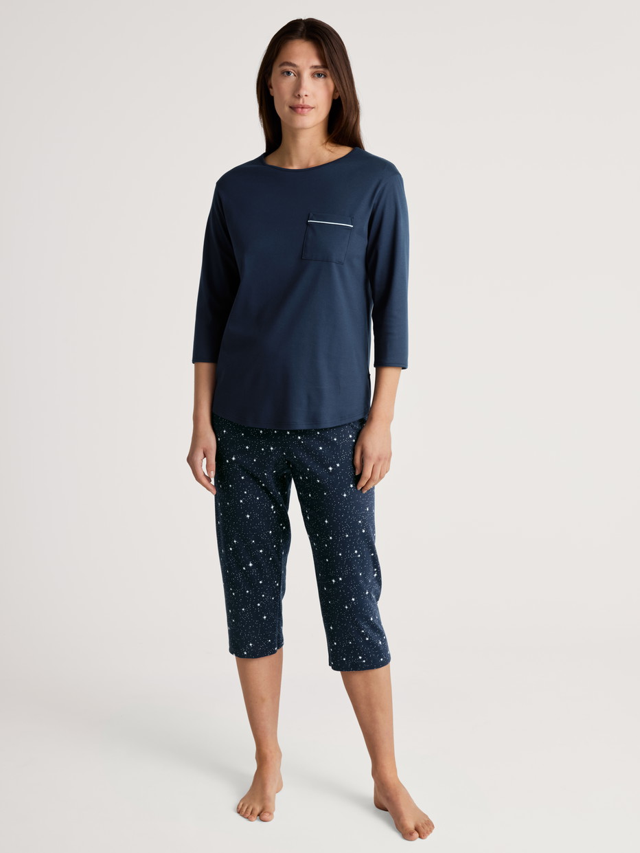 Women model is wearing 3/4 pyjama made of 100% Cotton in Blue, Motif from the Sweet Dreams series by CALIDA, Front view