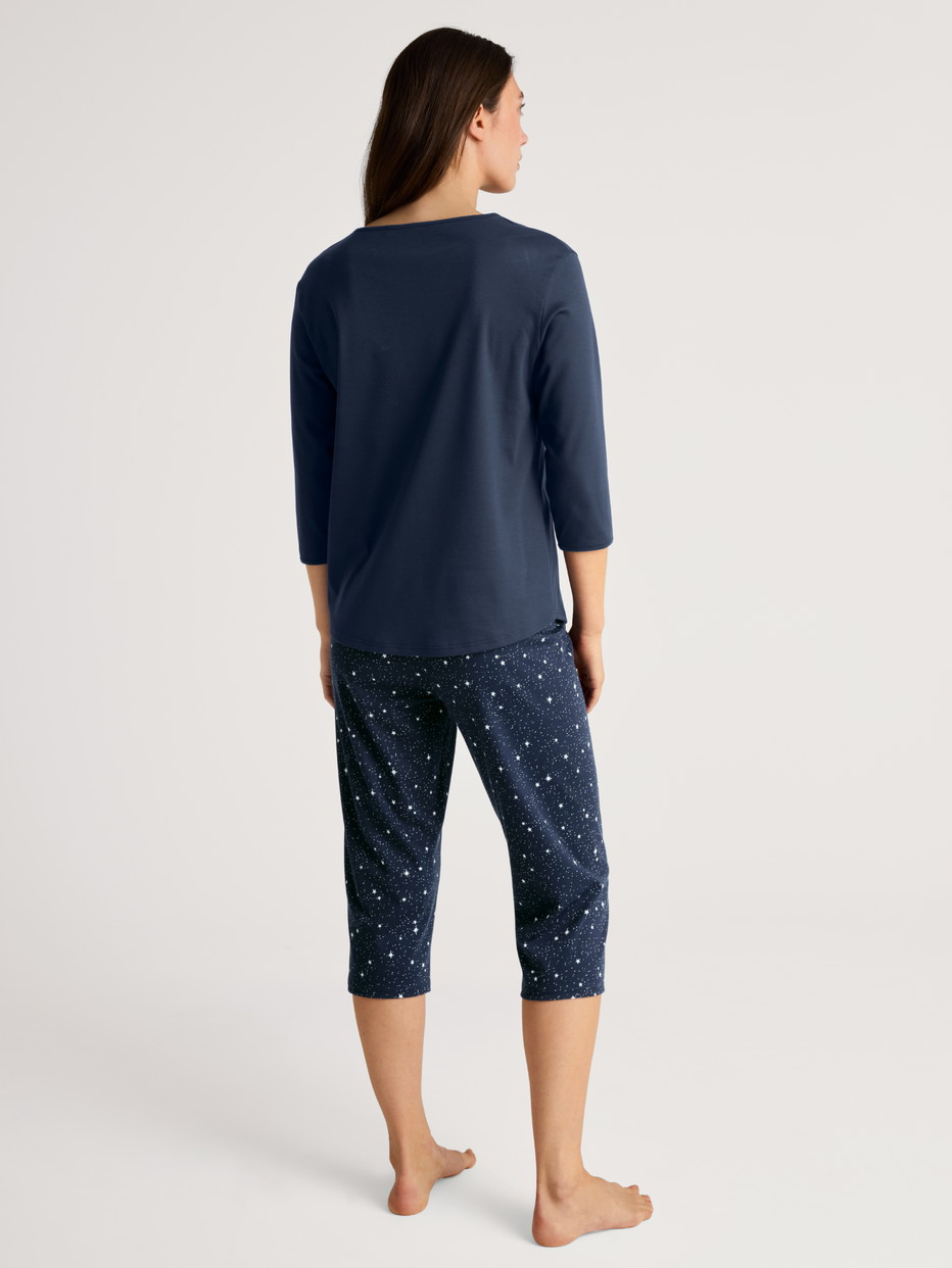 Women model is wearing 3/4 pyjama made of 100% Cotton in Blue, Motif from the Sweet Dreams series by CALIDA, Back view