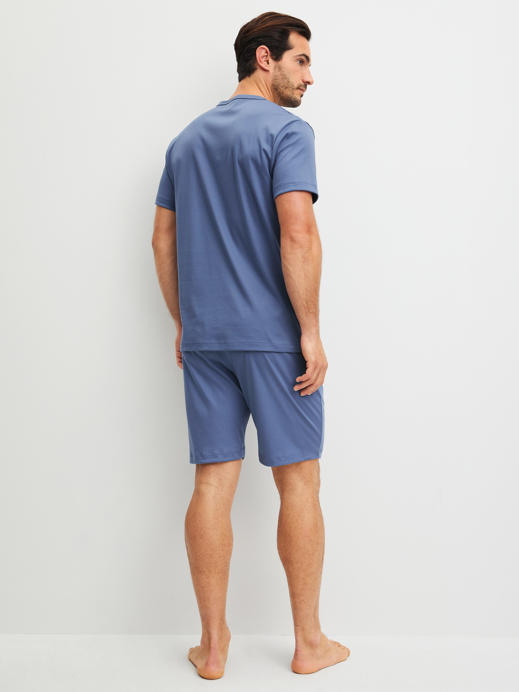 Herren-Model trägt Kurz-Pyjama aus 100% Baumwolle in Blau, Einfarbig aus Serie Relax Choice 1 von CALIDA, Rückansicht