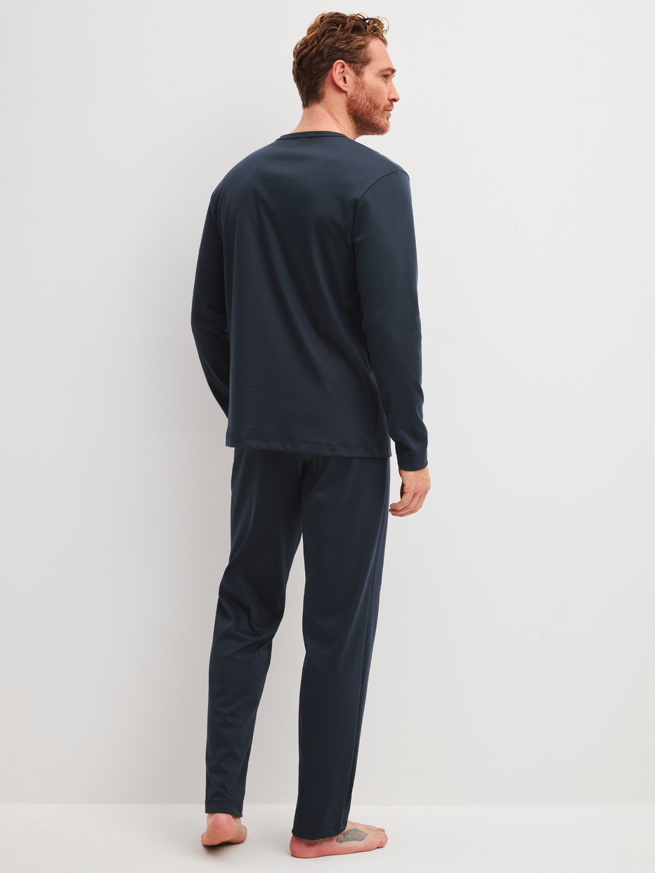 Herren-Model trägt Pyjama, lang aus 100% Baumwolle in Blau, Einfarbig aus Serie Relax Cosy Vibes 3 von CALIDA, Rückansicht