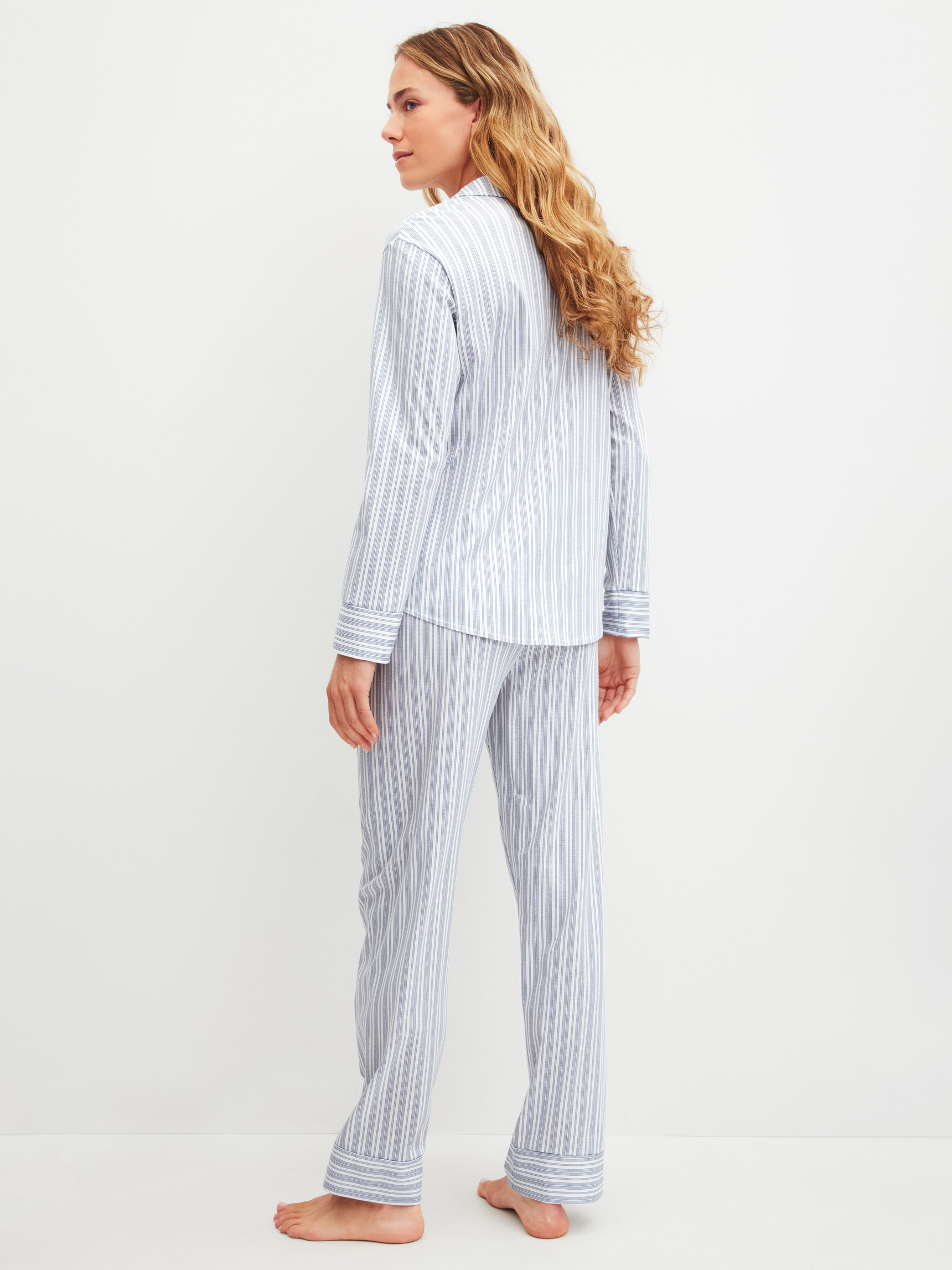 Damen-Model trägt Pyjama mit Knöpfen aus 100% Baumwolle in Blau, Gestreift aus Serie Striped Dreams von CALIDA, Rückansicht