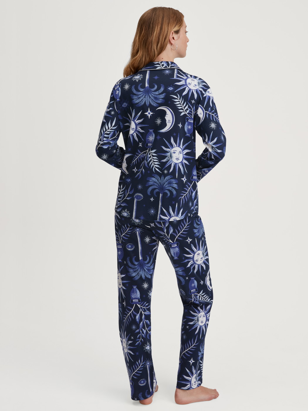 Women model is wearing Button-Up Pyjama made of 100% Cotton in Blue, Patterned from the Winter Dreams series by CALIDA, Back view
