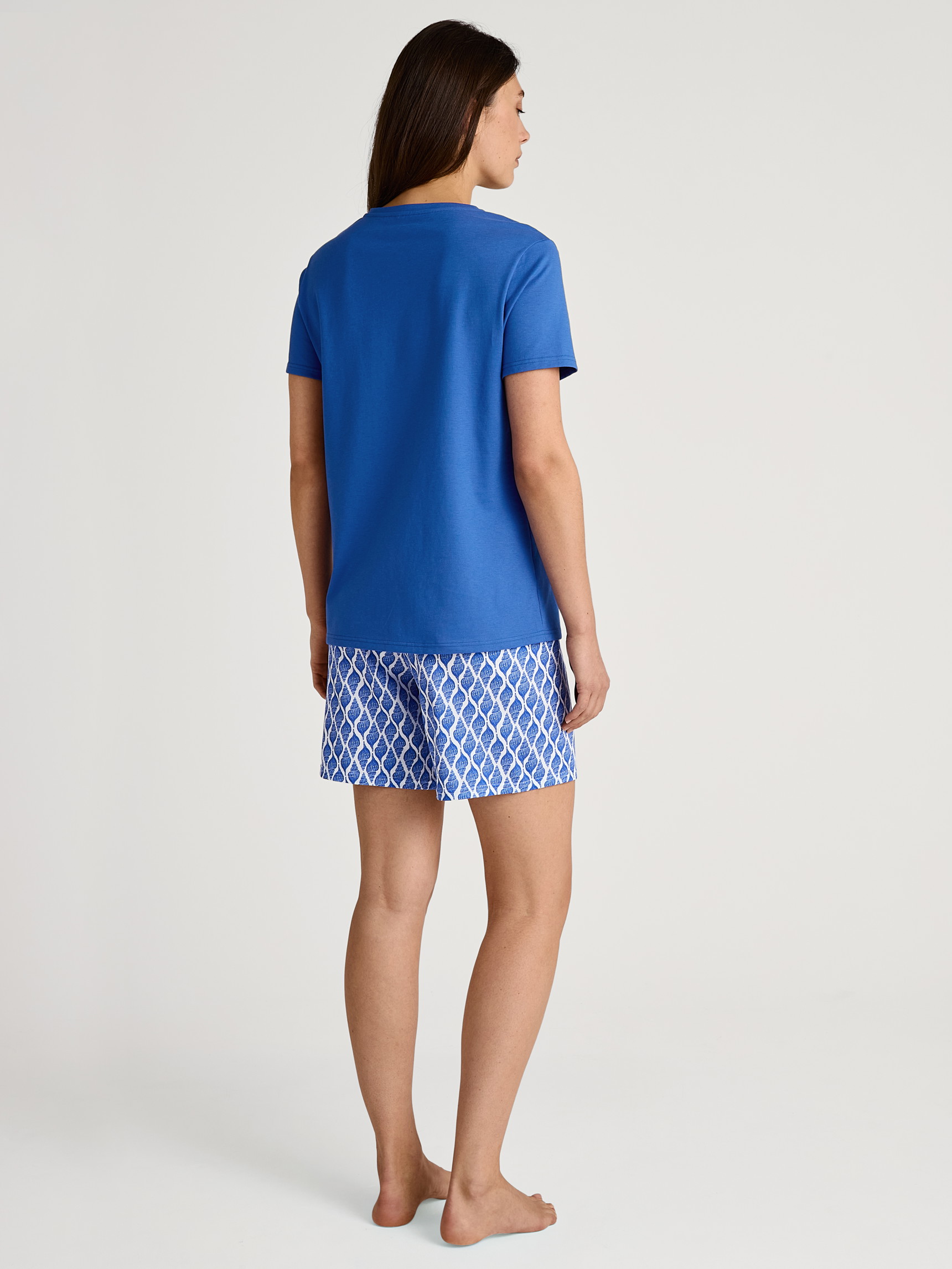 Women model is wearing Short pyjama made of 100% Cotton in Blue, Patterned from the Shell Nights series by CALIDA, Back view