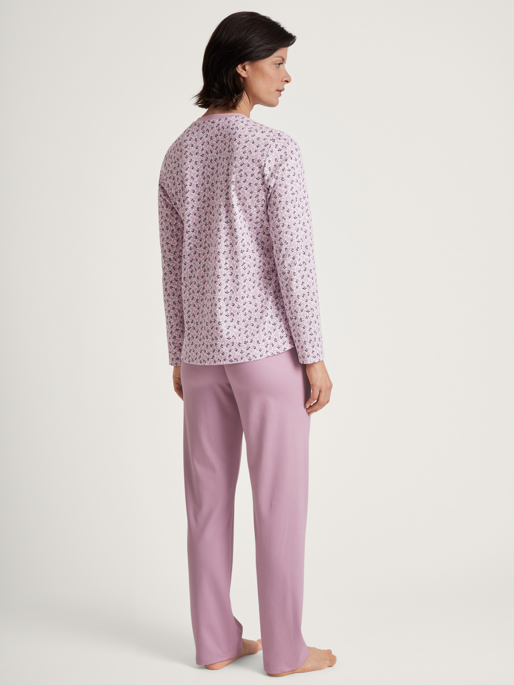 Women model is wearing Pyjamas, long made of 100% Cotton in Purple, Floral from the Midnight Flowers series by CALIDA, Back view