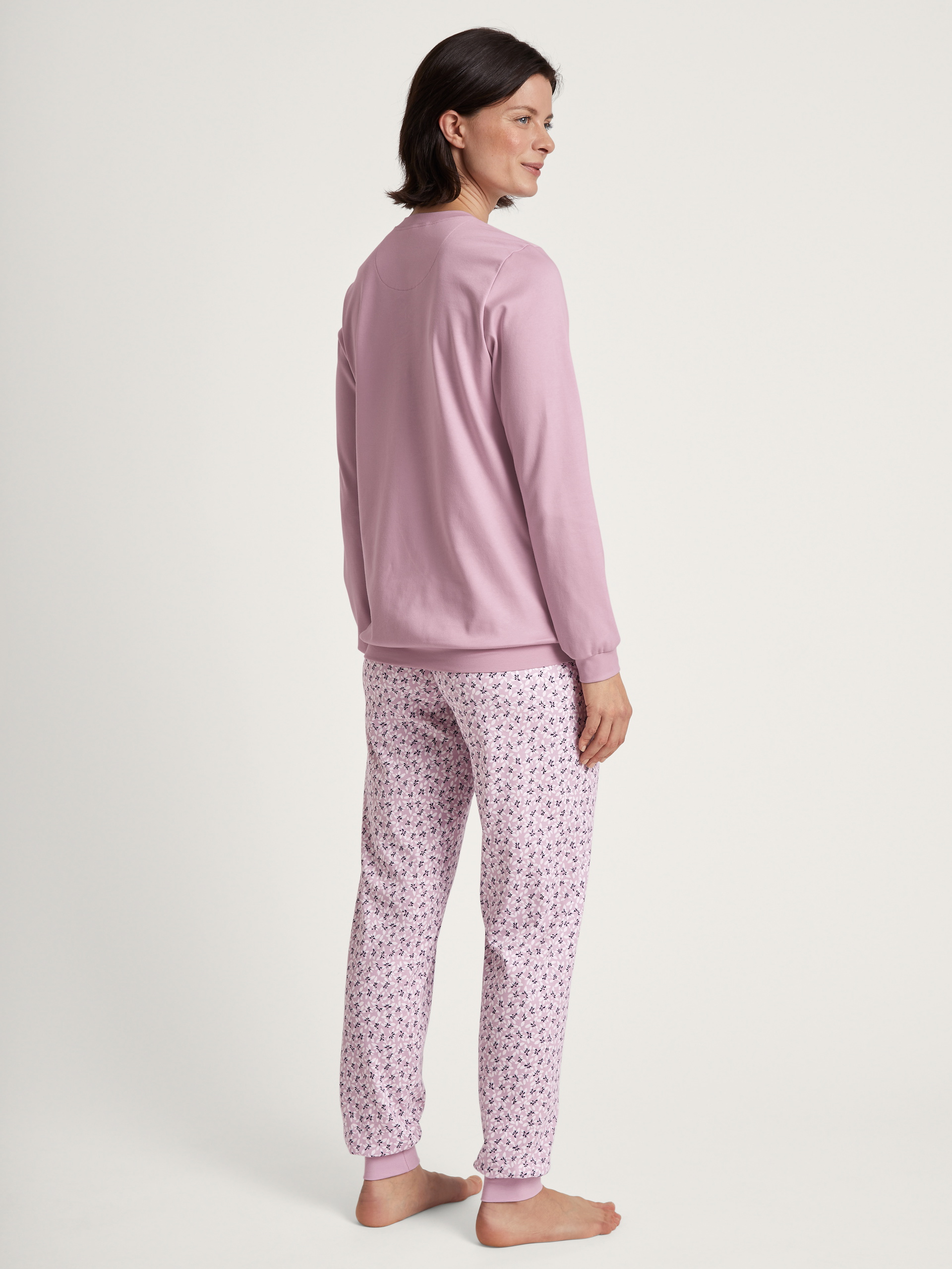 Women model is wearing Pyjama with cuff made of 100% Cotton in Purple, Floral from the Midnight Flowers series by CALIDA, Back view