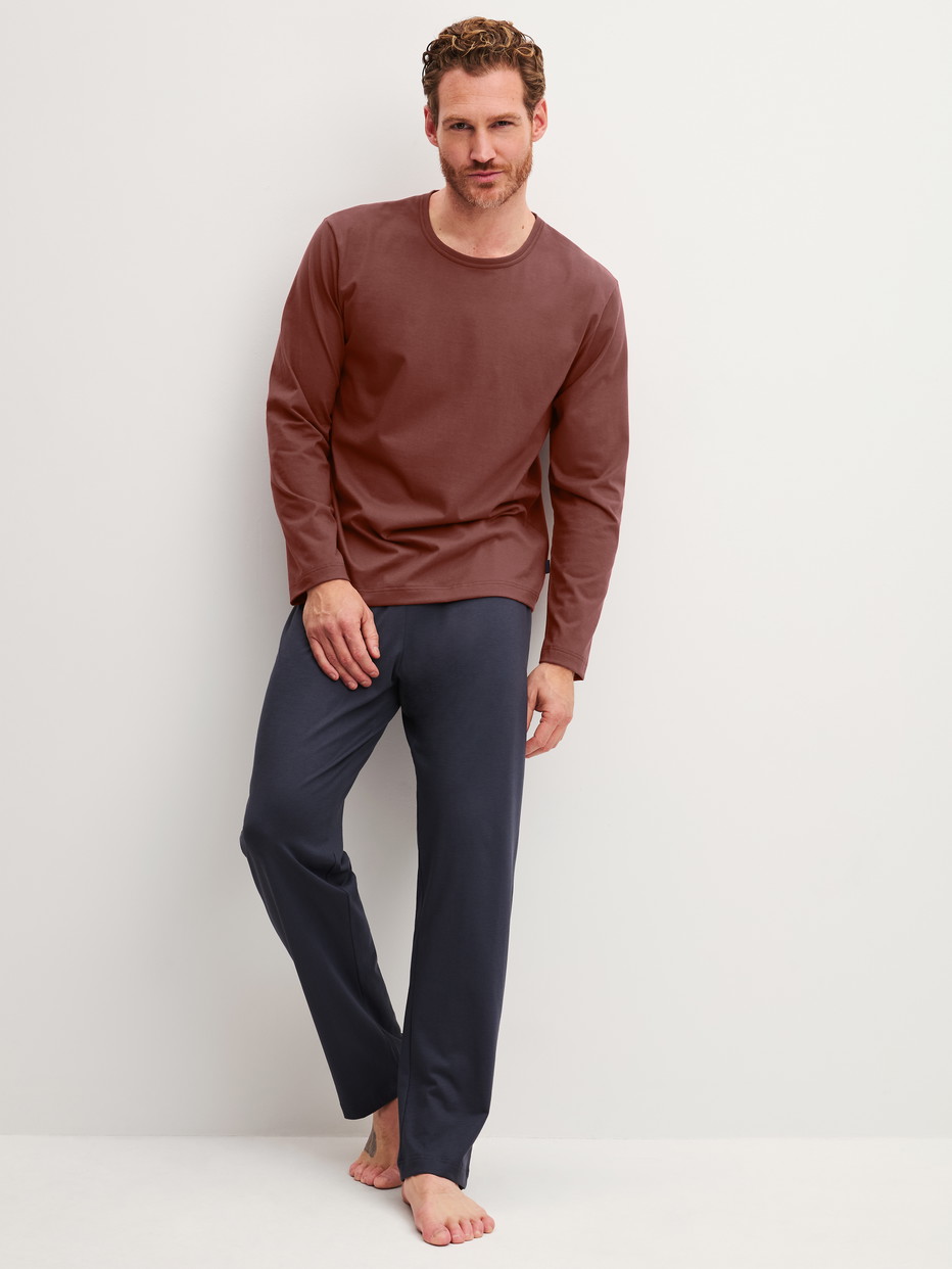 Herren-Model trägt Pyjama, lang aus 100% Baumwolle in Braun, Einfarbig aus Serie Relax Essentials von CALIDA, Vorderansicht