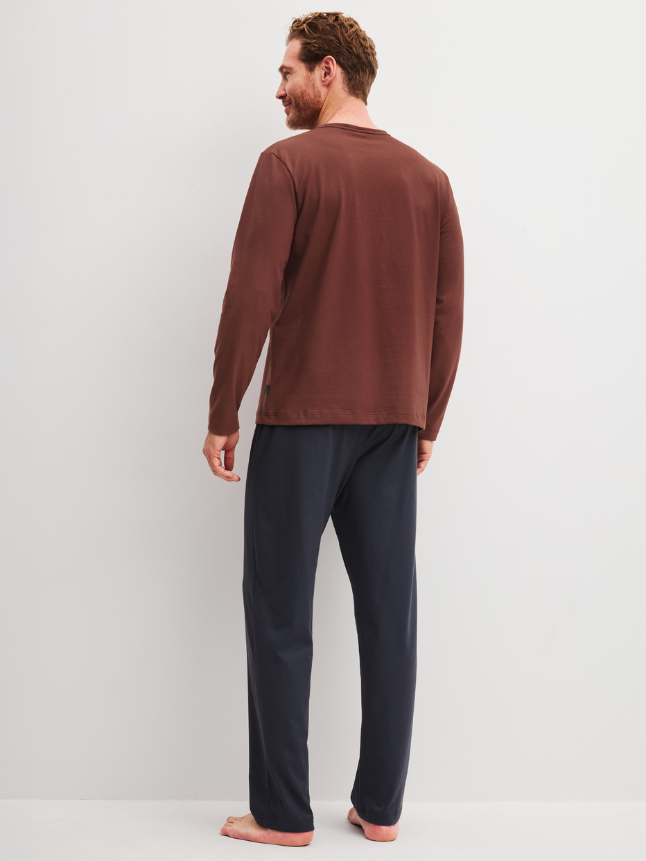 Herren-Model trägt Pyjama, lang aus 100% Baumwolle in Braun, Einfarbig aus Serie Relax Essentials von CALIDA, Rückansicht