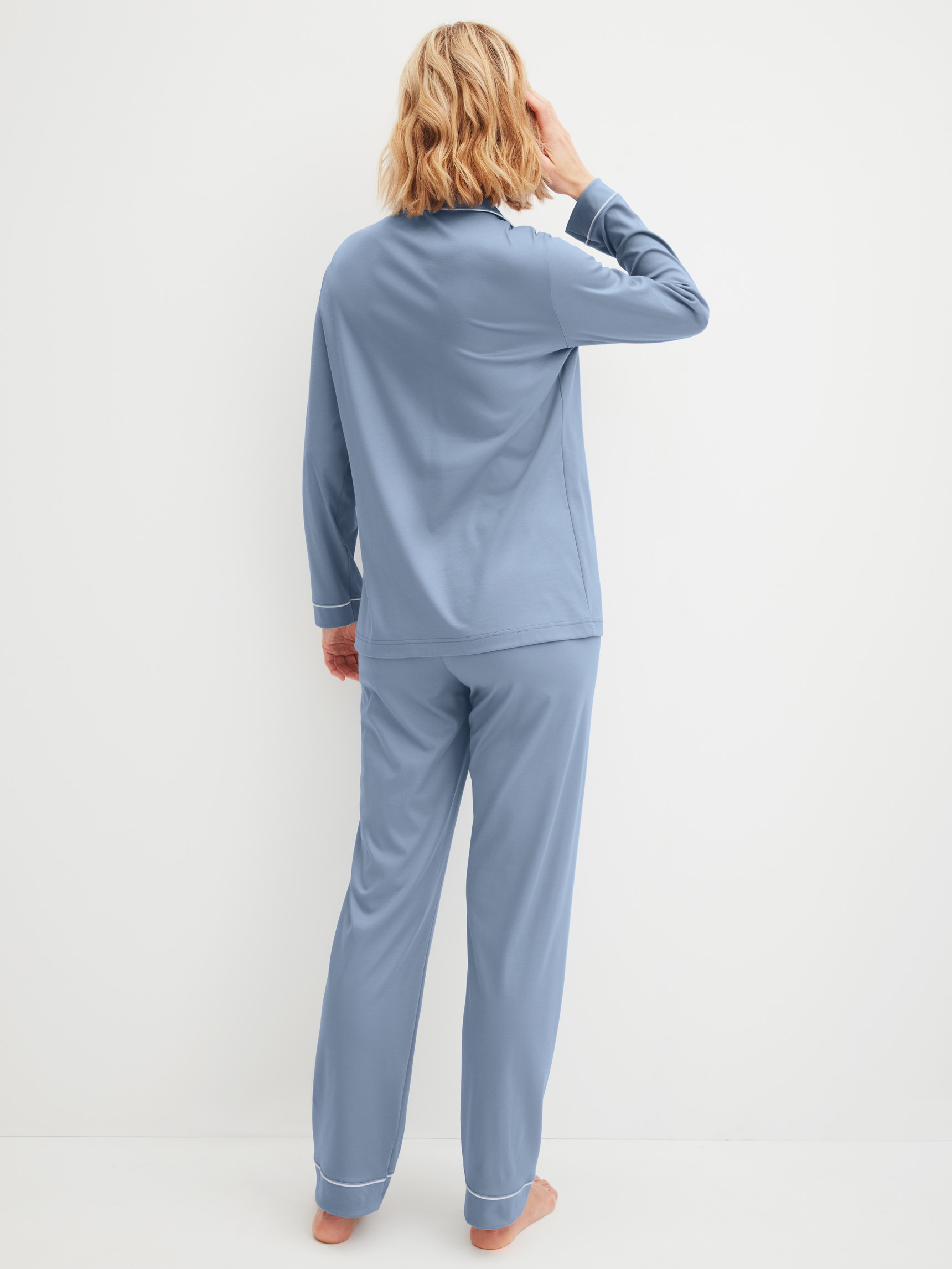 Women model is wearing Button-Up Pyjama made of 100% Cotton in Blue, Unicoloured from the Night Lovers series by CALIDA, Back view