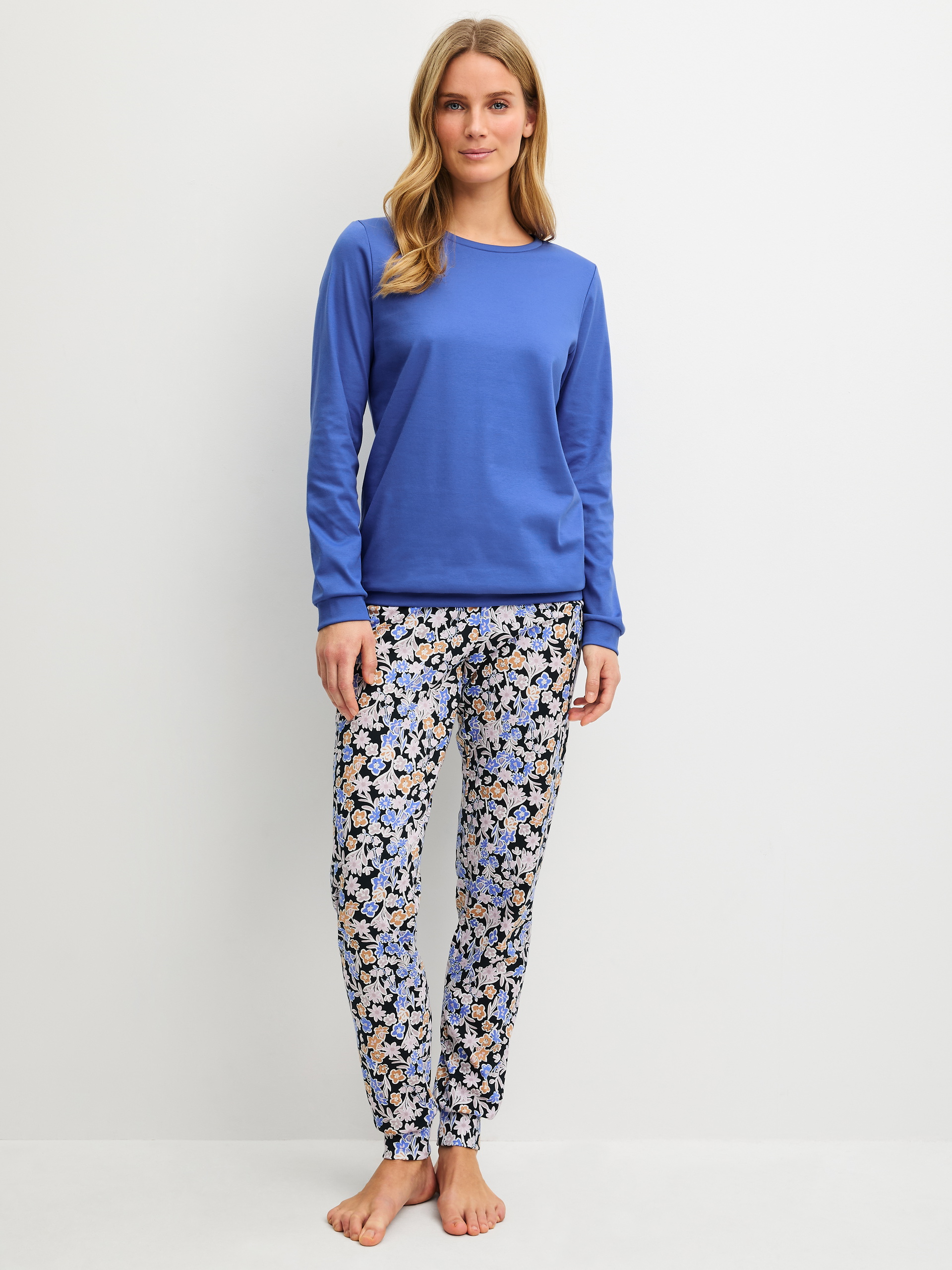 Women model is wearing Pyjama with cuff made of 100% Cotton in Blue, Patterned from the Flower Dreams series by CALIDA, Front view