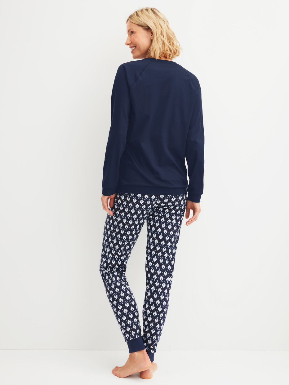 Damen-Model trägt Bündchen-Pyjama aus 100% Baumwolle in Blau, Gemustert aus Serie Daylight Dreams von CALIDA, Rückansicht