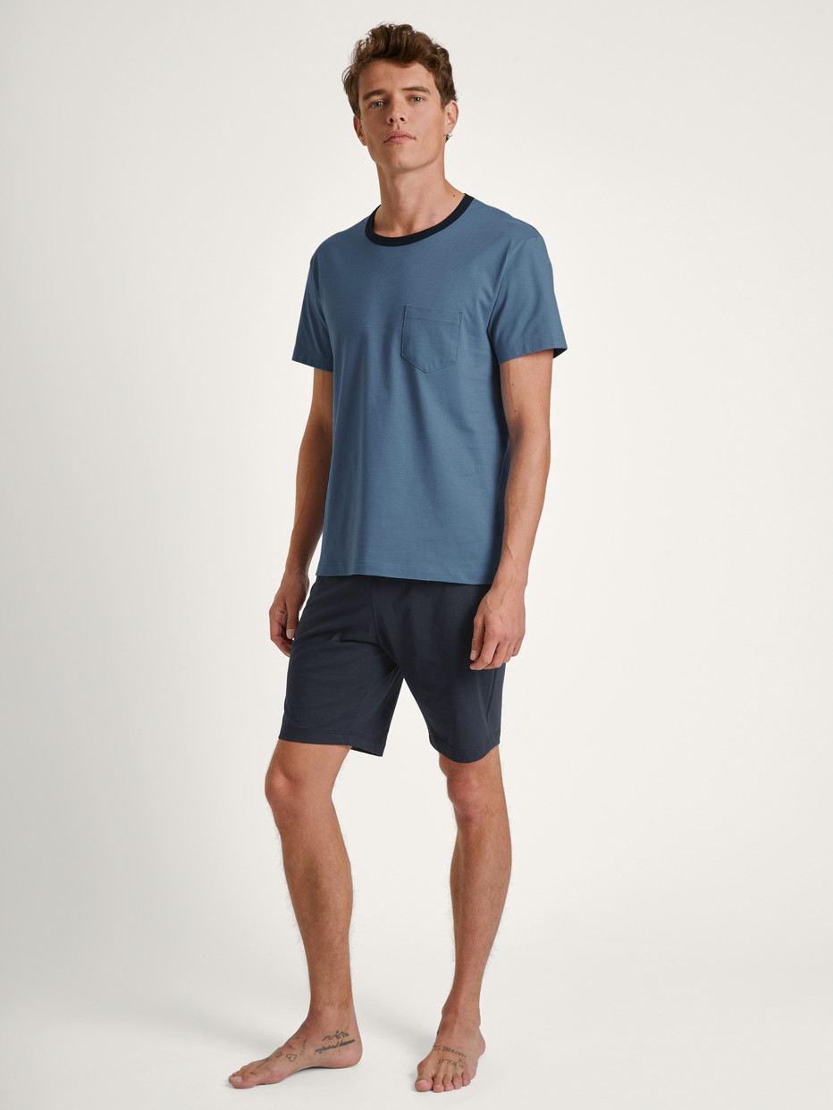 Herren-Model trägt Kurz-Pyjama aus 100% Baumwolle in Blau, Einfarbig aus Serie Relax Essentials von CALIDA, Vorderansicht