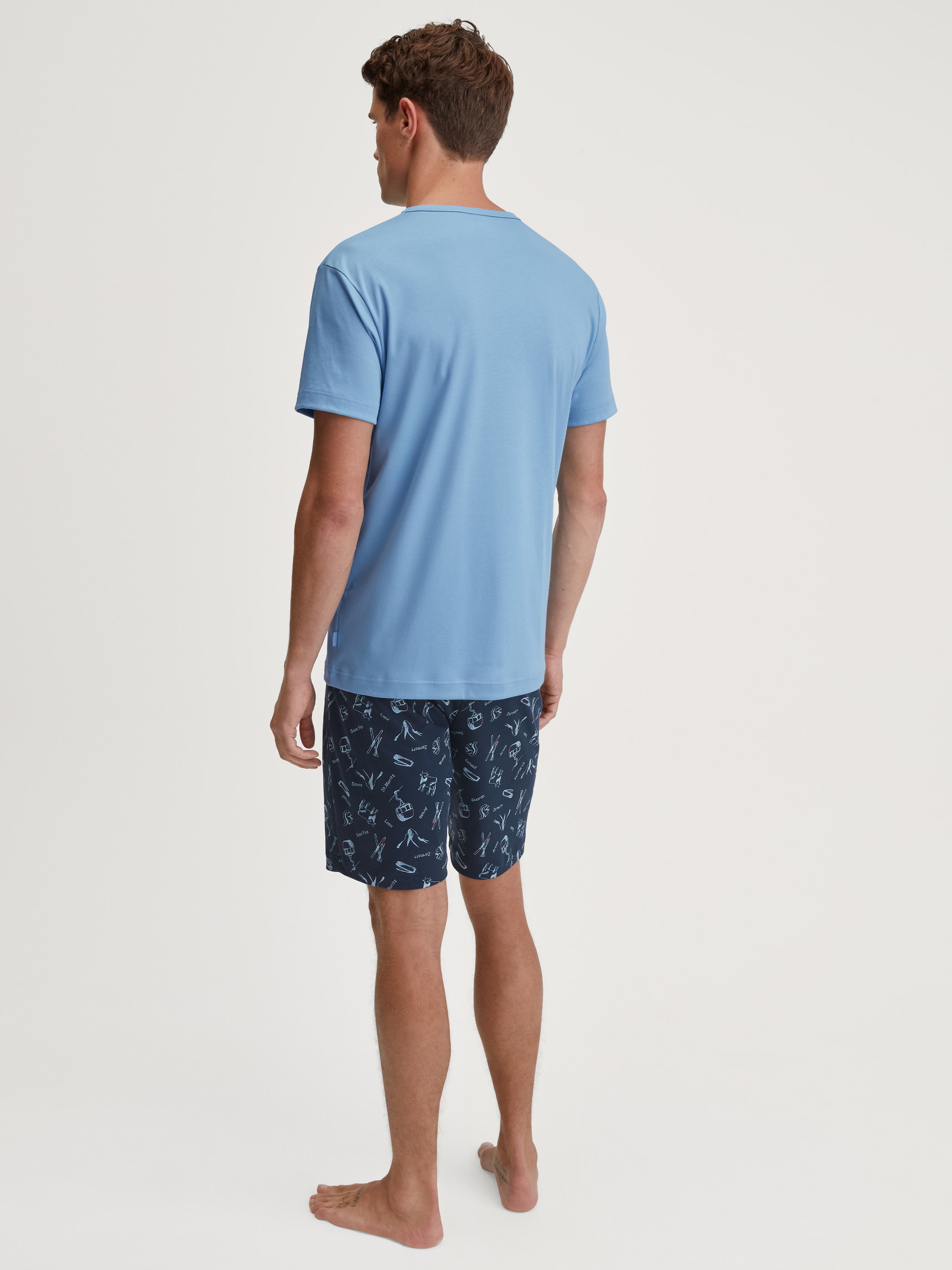 Herren-Model trägt Kurz-Pyjama aus 100% Baumwolle in Blau, Gemustert aus Serie Relax Swiss Resort von CALIDA, Rückansicht