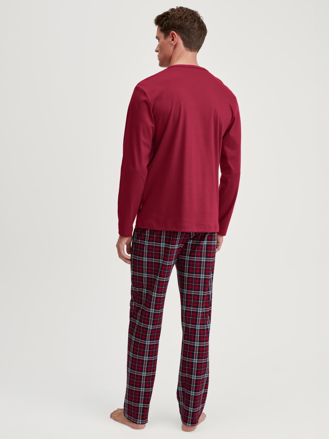 Herren-Model trägt Pyjama, lang aus 100% Baumwolle in Rot, Kariert aus Serie Family & Friends von CALIDA, Rückansicht