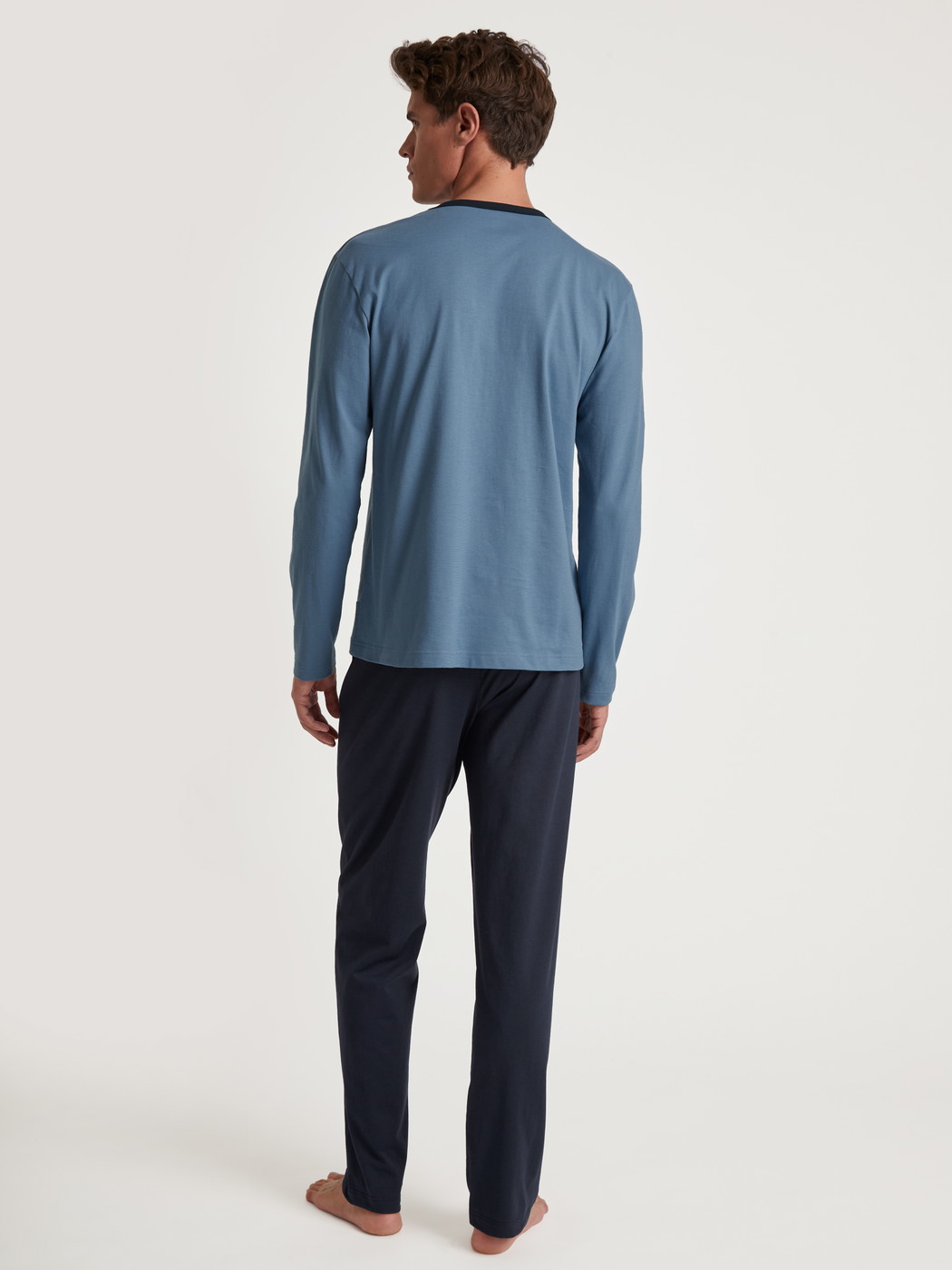 Men model is wearing Pyjama made of 100% Cotton in Blue, Unicoloured from the Relax Essentials series by CALIDA, Back view
