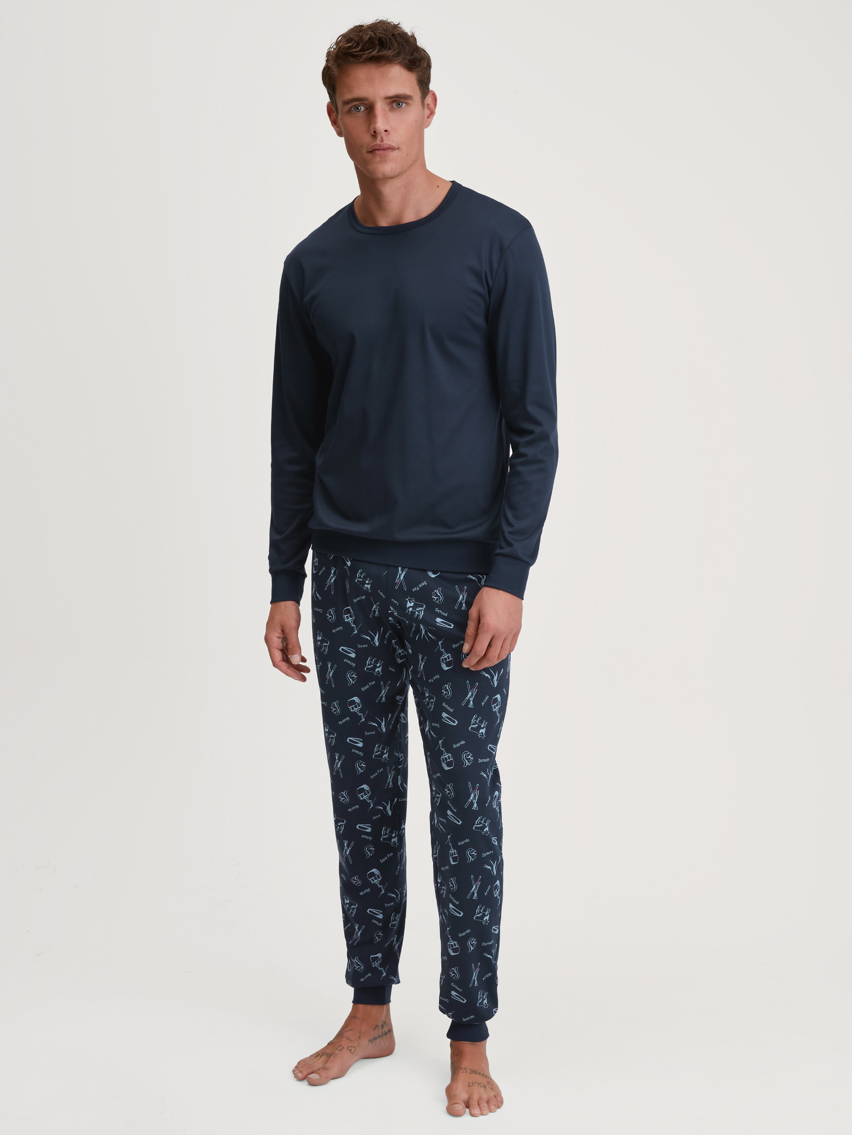 Men model is wearing Pyjama with cuff made of 100% Cotton in Blue, Patterned from the Relax Swiss Resort series by CALIDA, Front view